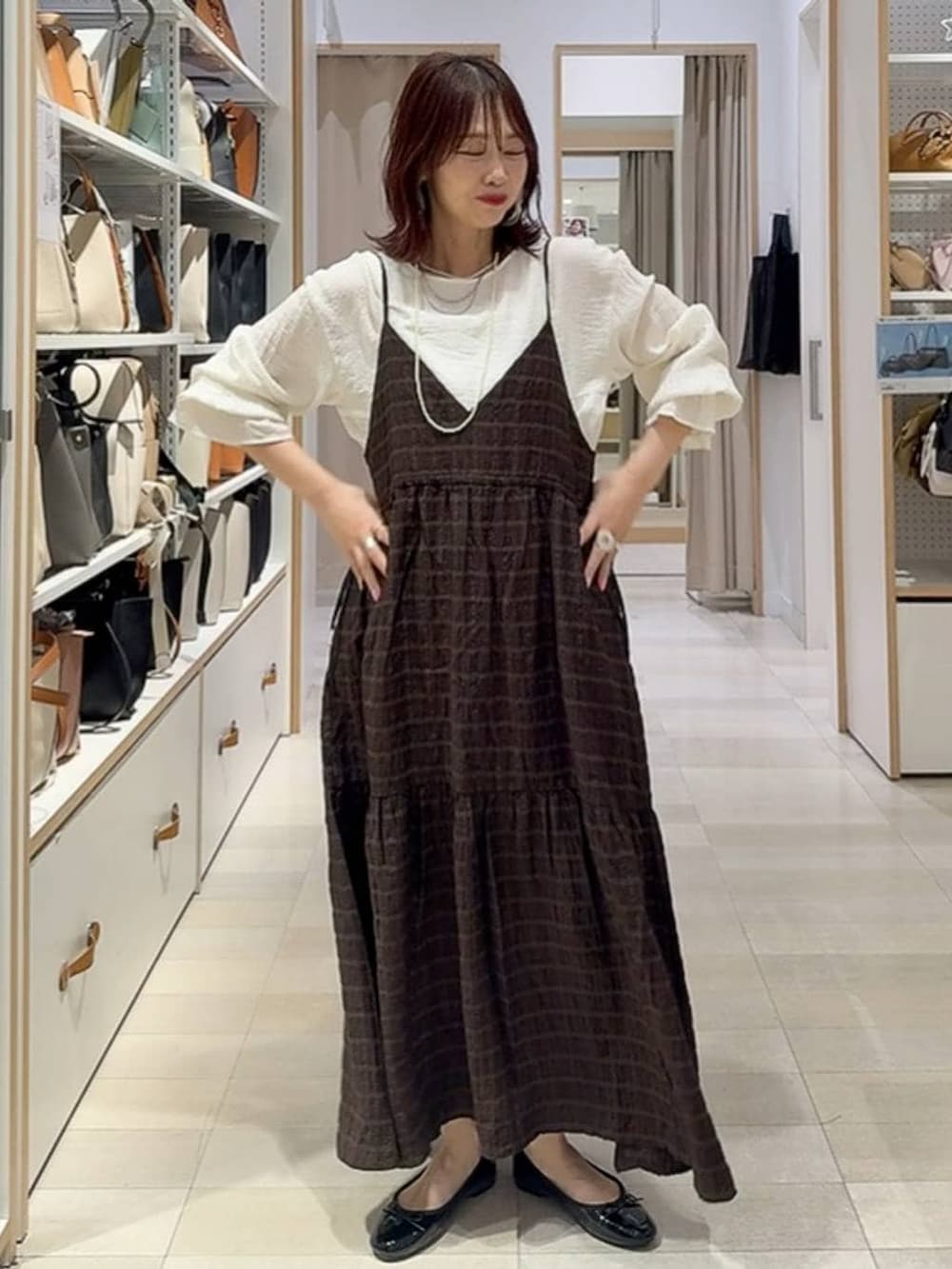 ブラック系のバレエシューズ、レッド系のショルダーバッグ、ブラウン系のワンピースを着用したレディースの春コーディネートの3枚目の写真