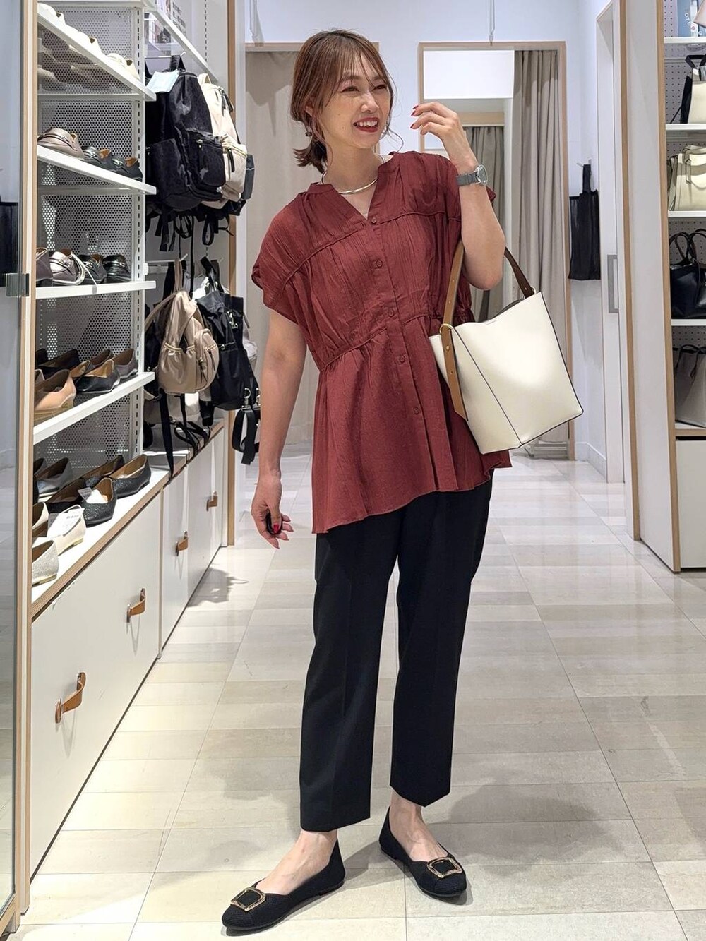 ブルー系のデニムパンツ、ベージュ系のキャミソール、ベージュ系のトートバッグを着用したレディースの夏コーディネートの4枚目の写真