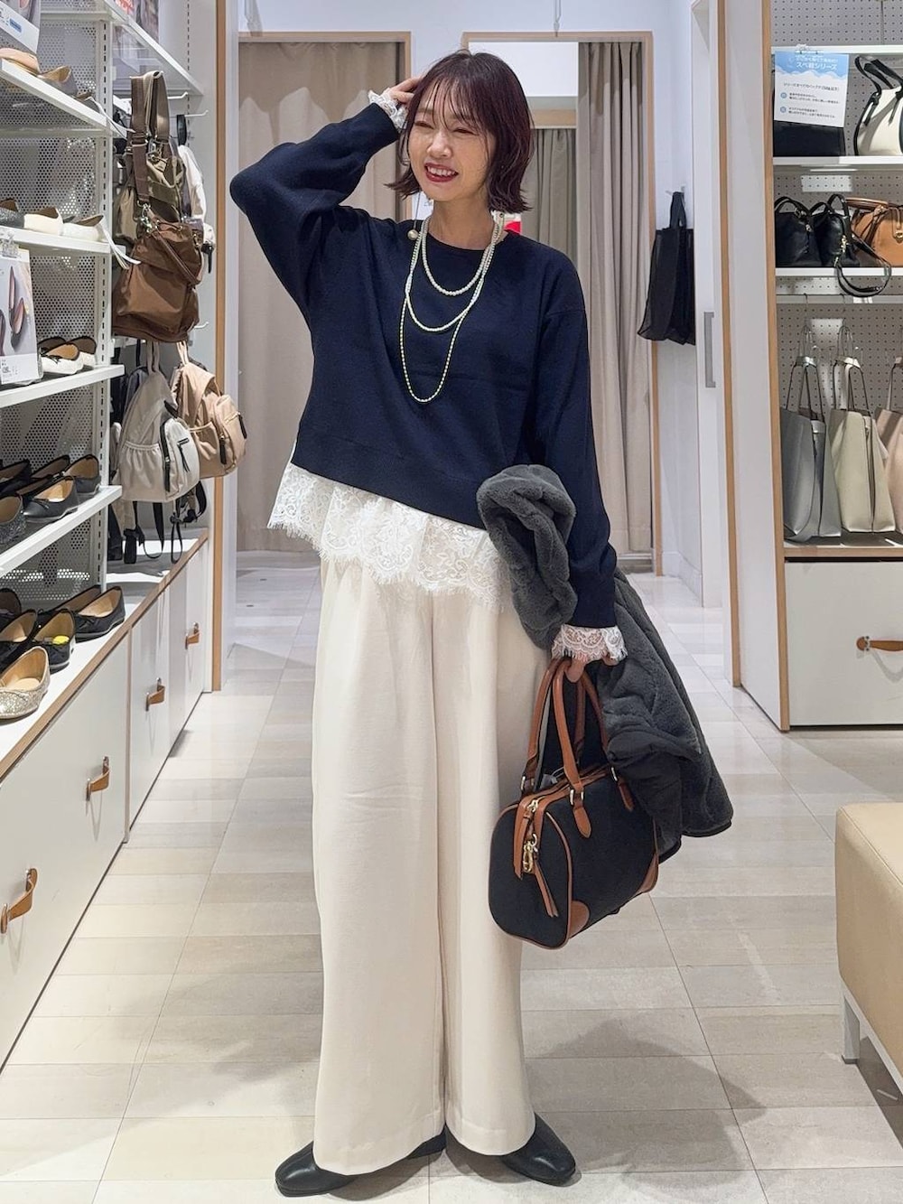 グレー系のブルゾン、グレー系のその他パンツ、ブラック系のボストンバッグを着用したレディースの秋コーディネートの3枚目の写真