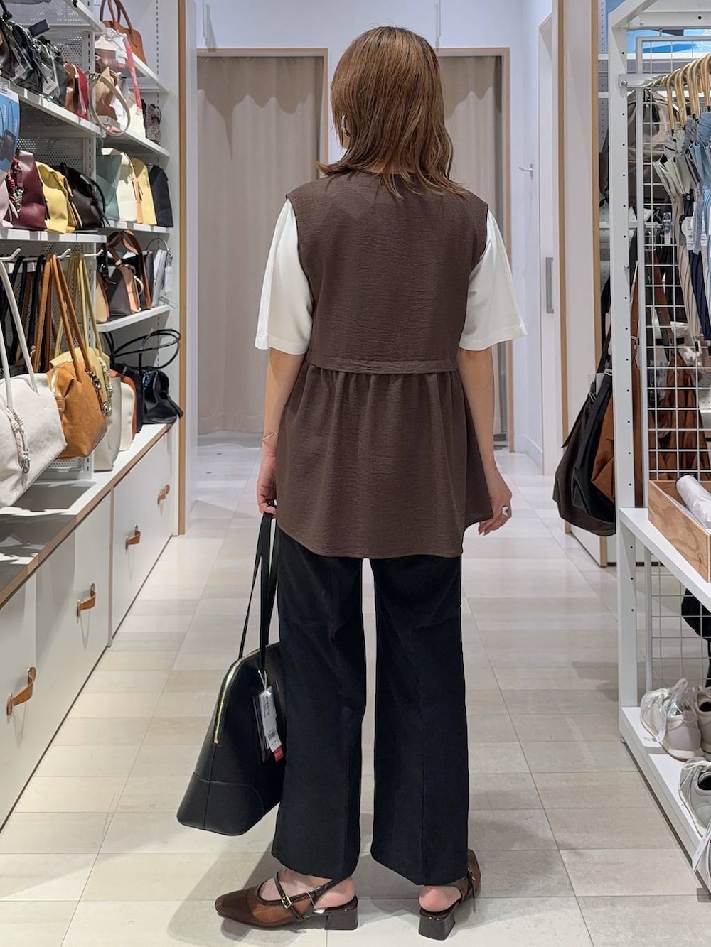 ブラック系のボストンバッグ、ブラック系のその他パンツ、ブラウン系のベストを着用したレディースの夏コーディネートの5枚目の写真