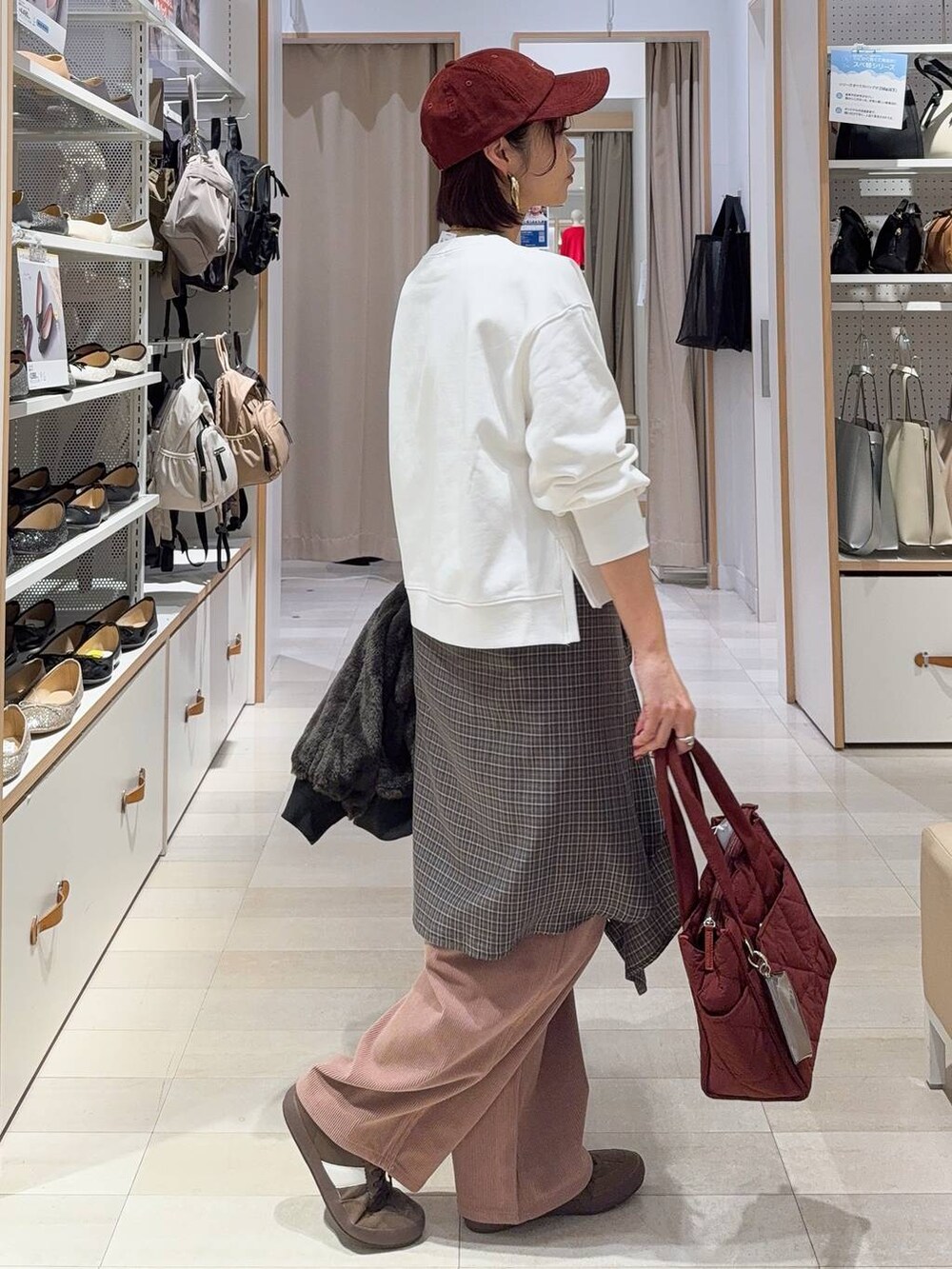 レッド系のトートバッグ、ブラック系のブルゾン、ピンク系のその他パンツを着用したレディースの秋コーディネートの6枚目の写真