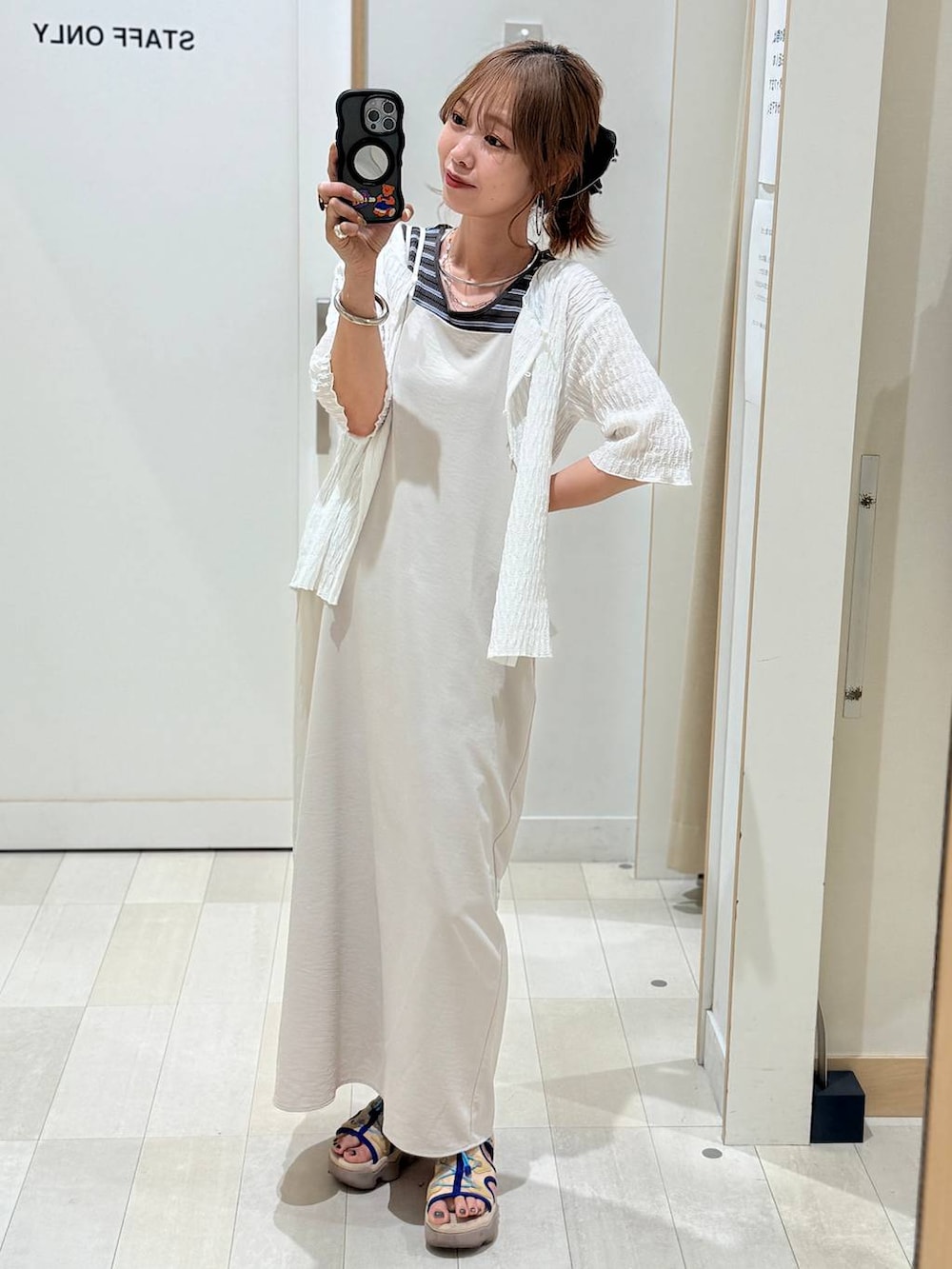 ブルー系のデニムパンツ、ブラウン系のテーラードジャケット、グレー系のベストを着用したレディースの春コーディネートの2枚目の写真