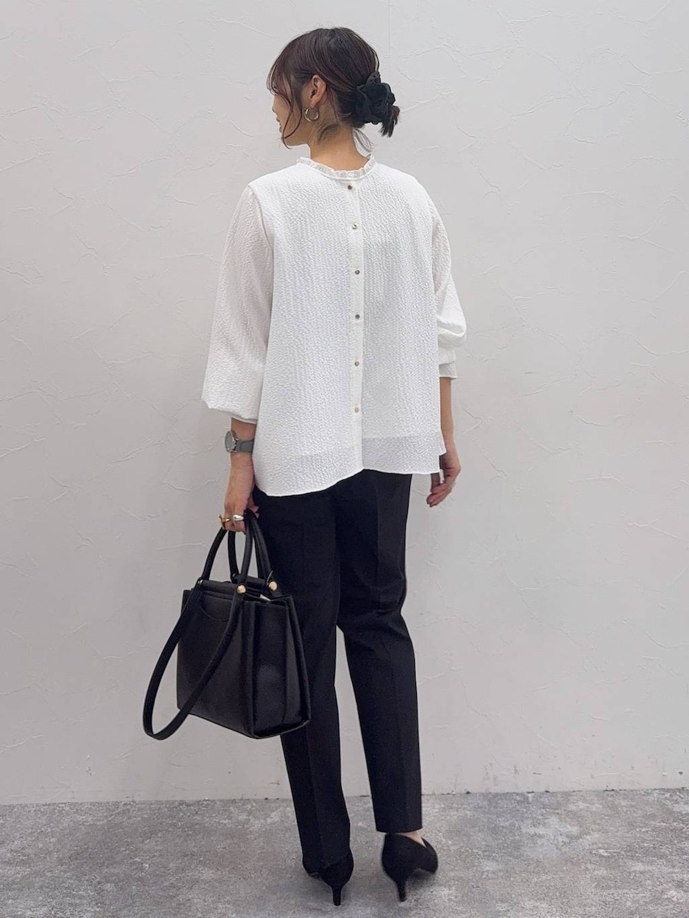 ブラック系のパンプス、ホワイト系のシャツ/ブラウス、ブラック系のスラックスを着用したレディースの冬コーディネートの9枚目の写真