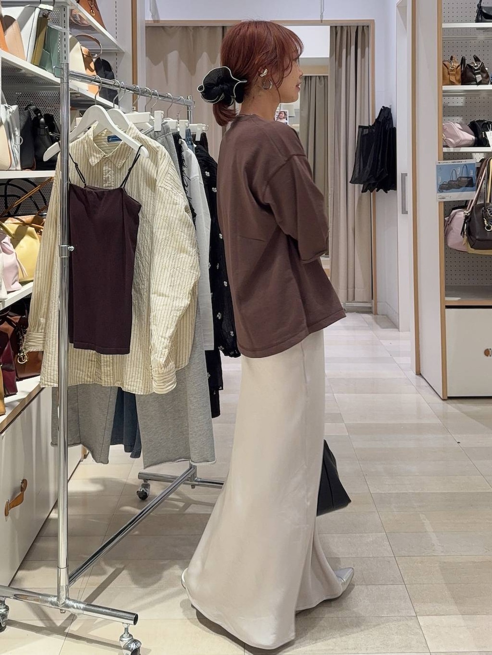 ブラック系のTシャツ/カットソー、グレー系のスカート、ブラウン系のスウェットを着用したレディースの春コーディネートの5枚目の写真