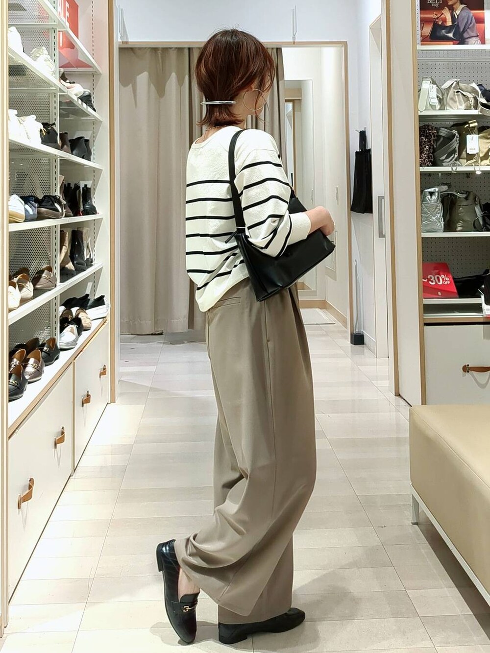 ブラック系のローファー、ブラック系のショルダーバッグ、ホワイト系のニット/セーターを着用したレディースの春コーディネートの3枚目の写真