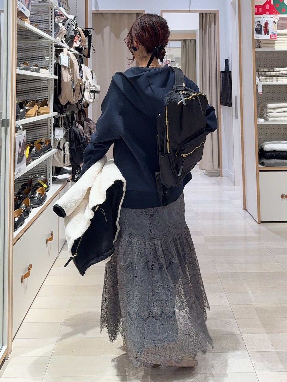 ホワイト系のブルゾン、ブルー系のデニムパンツ、ブラック系のバックパック/リュックを着用したレディースの冬コーディネートの9枚目の写真