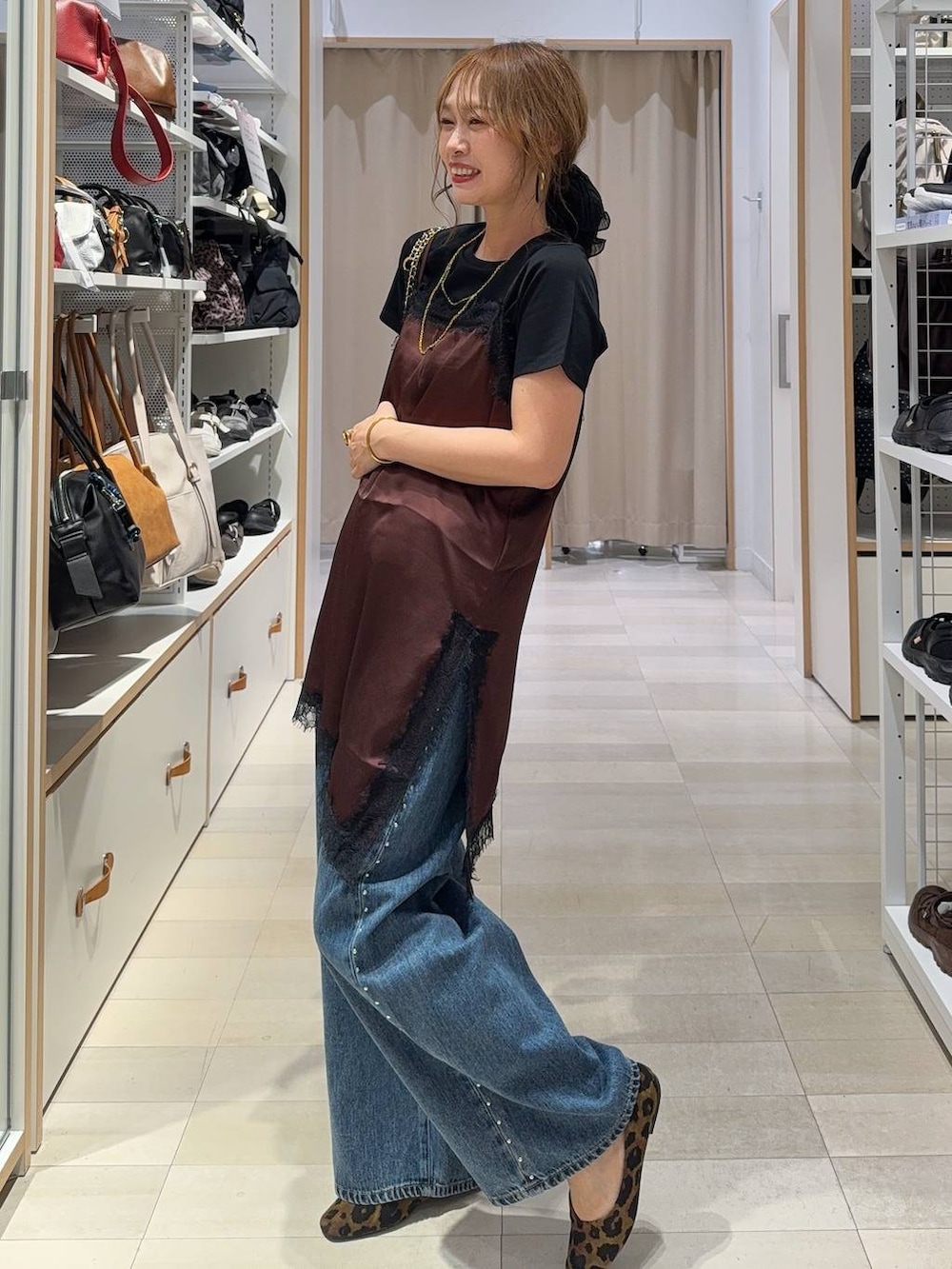 ブルー系のデニムパンツ、ブラウン系のキャミソール、その他のパンプスを着用したレディースの夏コーディネートの2枚目の写真