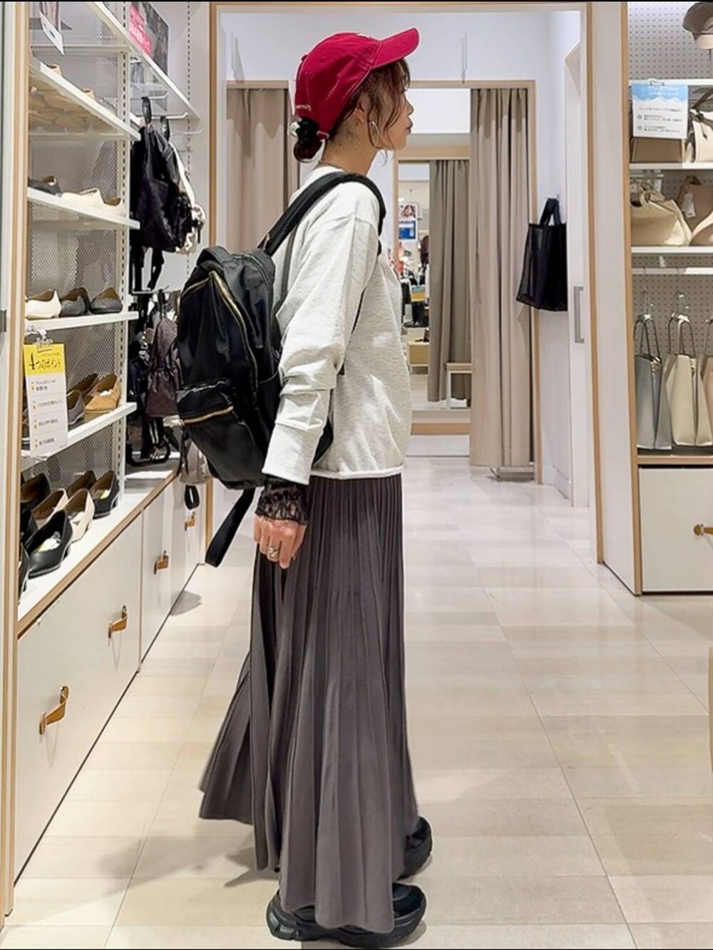 ブラック系のバックパック/リュック、ブラック系のスニーカー、グレー系のスカートを着用したレディースの秋コーディネートの6枚目の写真