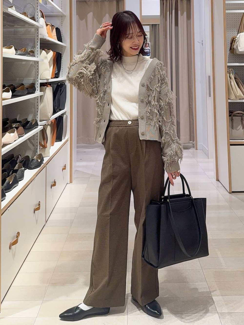 ブラック系のバレエシューズ、その他のトートバッグ、ブルー系のデニムパンツを着用したレディースの春コーディネートの3枚目の写真