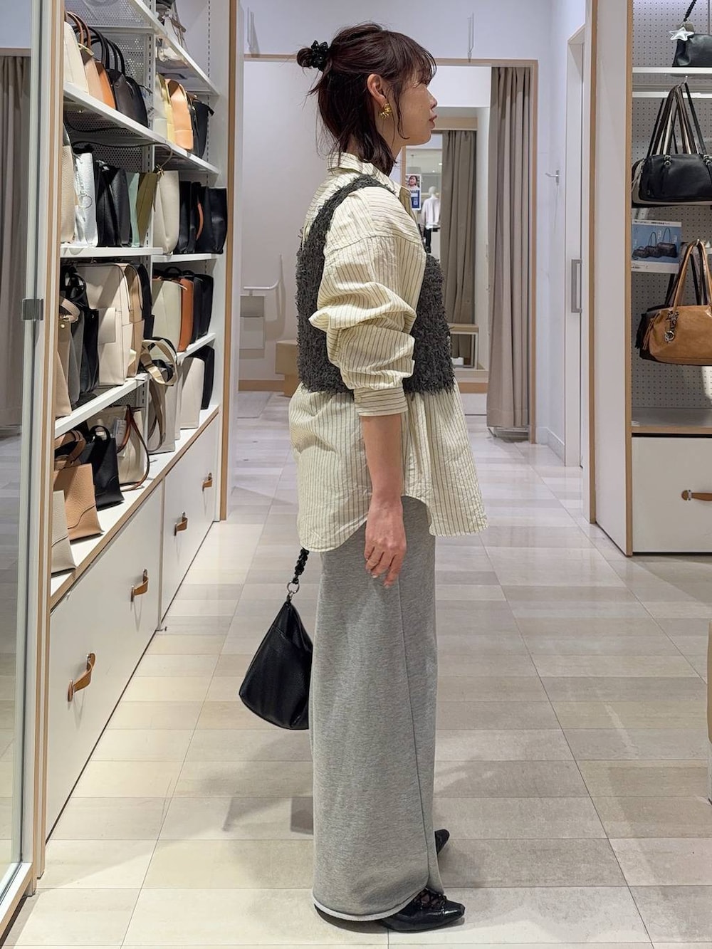 イエロー系のシャツ/ブラウス、グレー系のスウェットパンツ、グレー系のベストを着用したレディースの春コーディネートの7枚目の写真