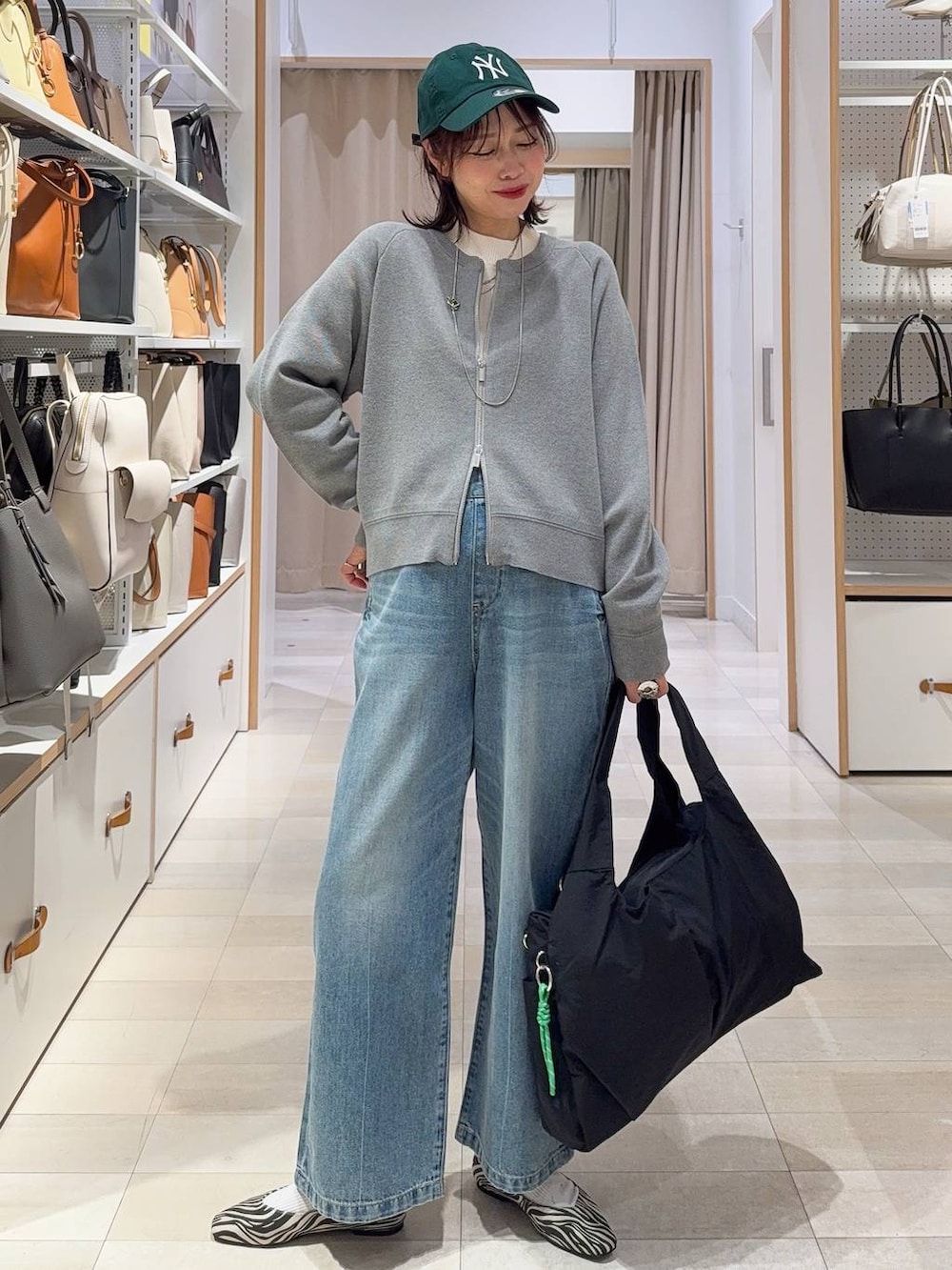 ブラック系のブーツ、グレー系のスカート、グレー系のカーディガン/ボレロを着用したレディースの冬コーディネートの2枚目の写真