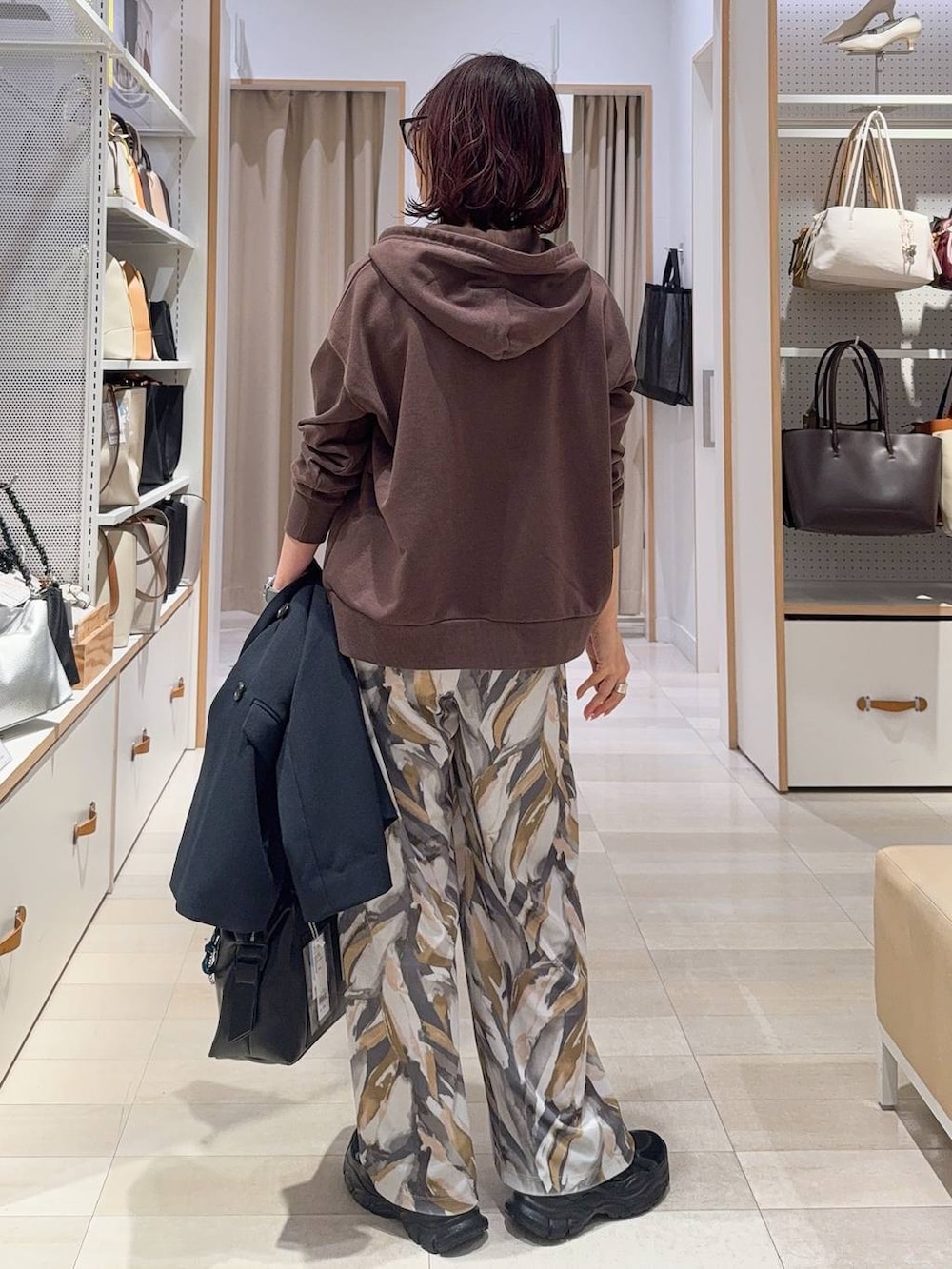 ブラック系のボストンバッグ、ブラック系のスニーカー、ブルー系のテーラードジャケットを着用したレディースの冬コーディネートの9枚目の写真