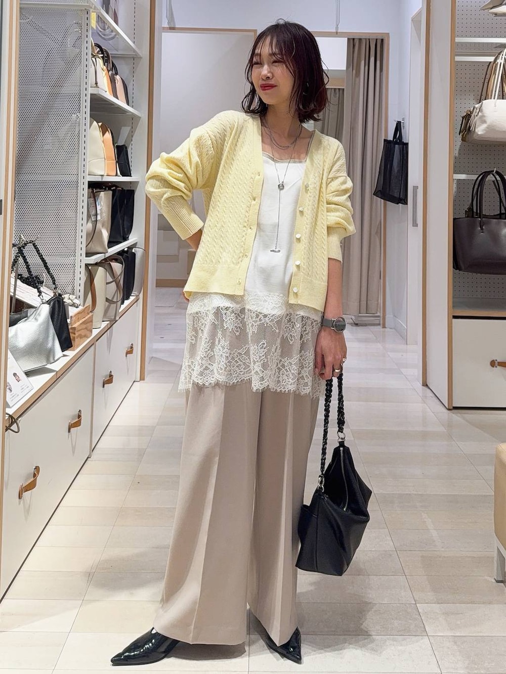 ゴールド系のタンクトップ、ブルー系のチェスターコート、イエロー系のカーディガン/ボレロを着用したレディースの冬コーディネートの3枚目の写真