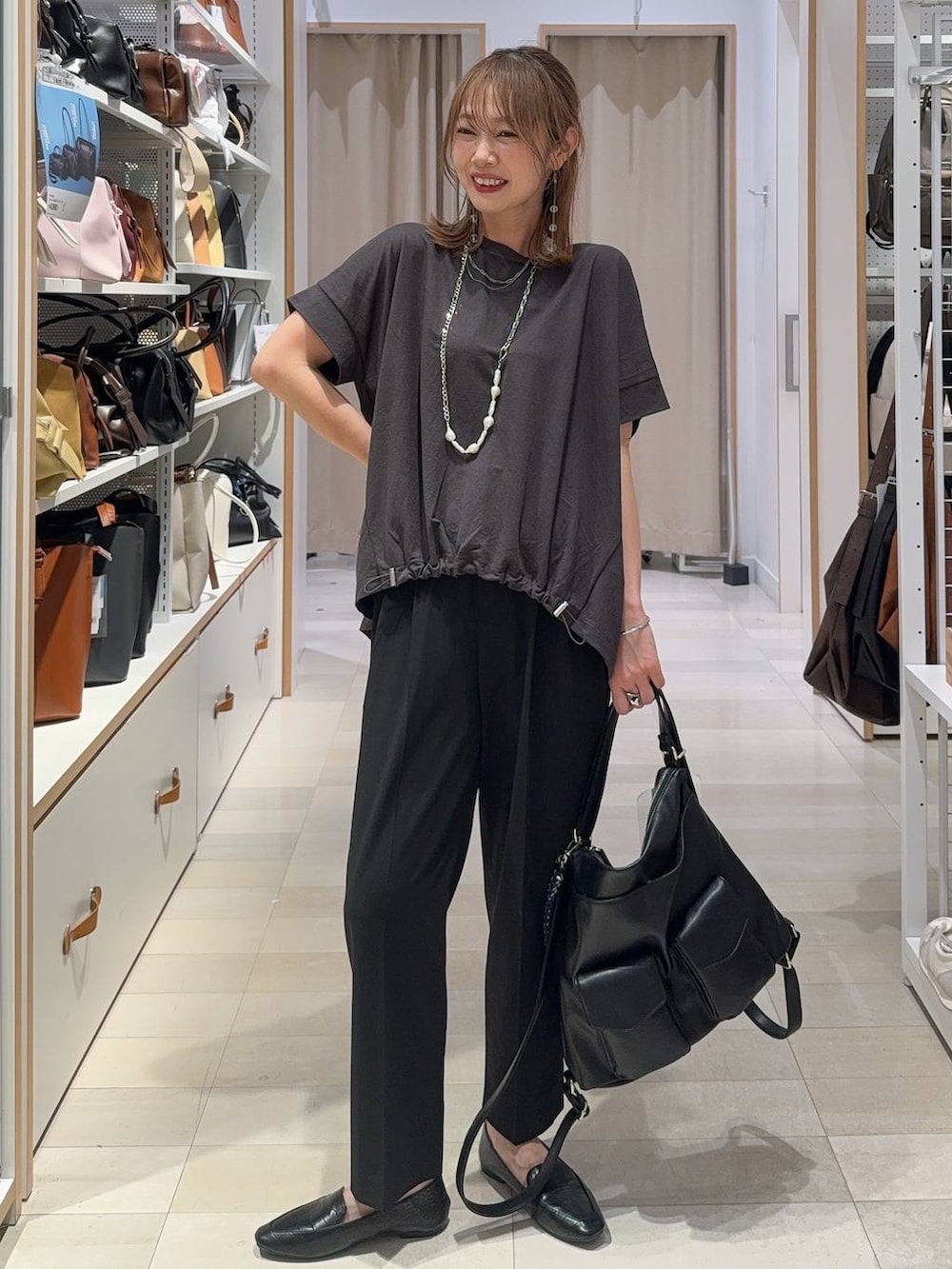 ホワイト系のパンプス、ブラック系のその他パンツ、ベージュ系のタンクトップを着用したレディースの夏コーディネートの2枚目の写真