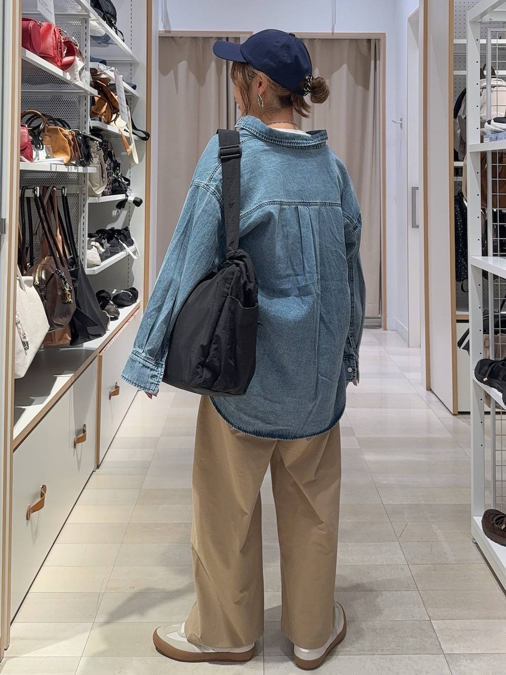 ホワイト系のスニーカー、ブラック系のショルダーバッグ、ホワイト系のTシャツ/カットソーを着用したレディースの秋コーディネートの6枚目の写真