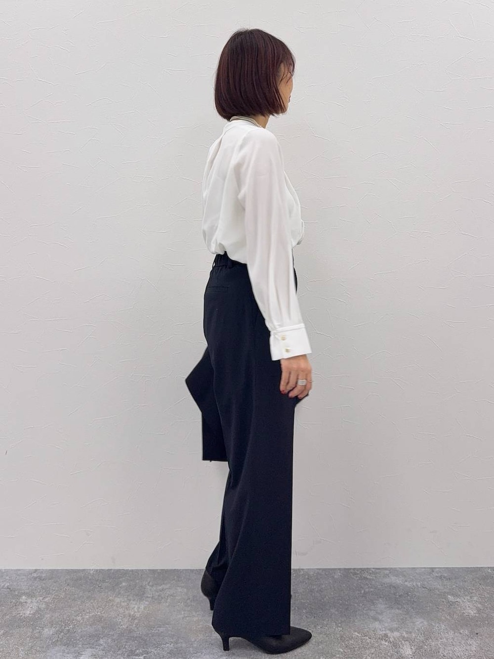 ブラック系のショルダーバッグ、ブルー系のスラックス、ホワイト系のシャツ/ブラウスを着用したレディースの秋コーディネートの5枚目の写真