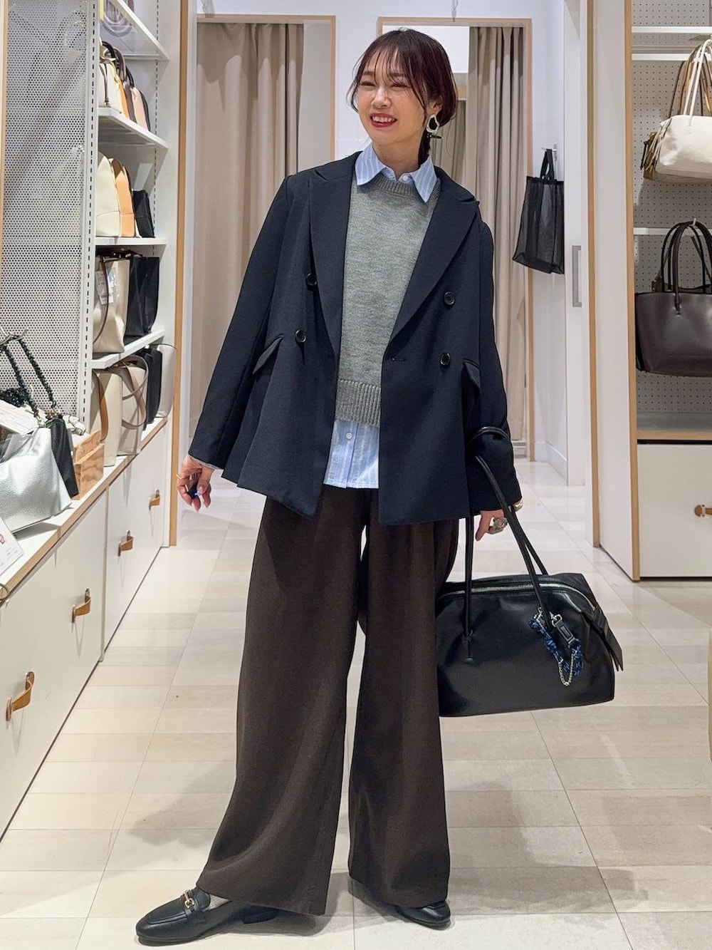 ブラック系のローファー、ブラック系のボストンバッグ、ブルー系のテーラードジャケットを着用したレディースの冬コーディネートの2枚目の写真