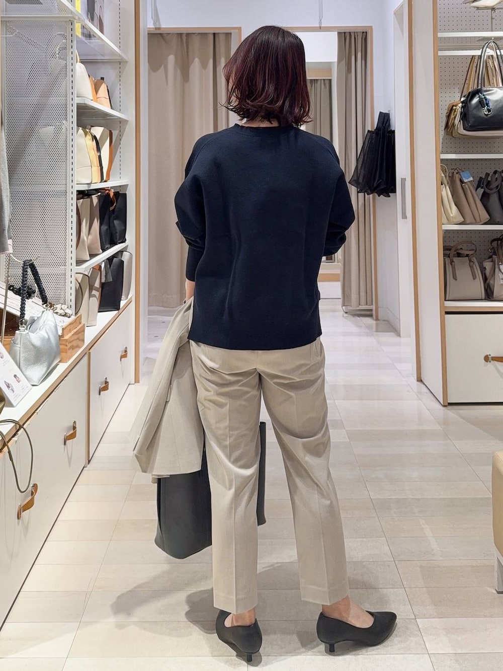 ベージュ系のスラックス、ベージュ系のノーカラージャケット、グレー系のトートバッグを着用したレディースの冬コーディネートの7枚目の写真