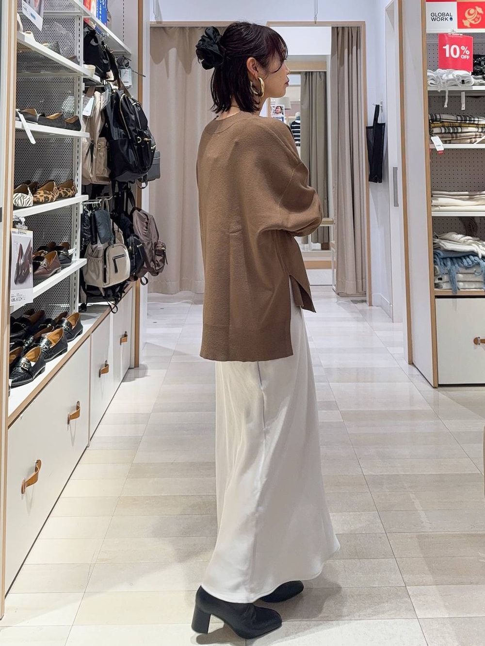 ブラック系のその他アウター、ブラック系のブーツ、グレー系のスカートを着用したレディースの冬コーディネートの7枚目の写真