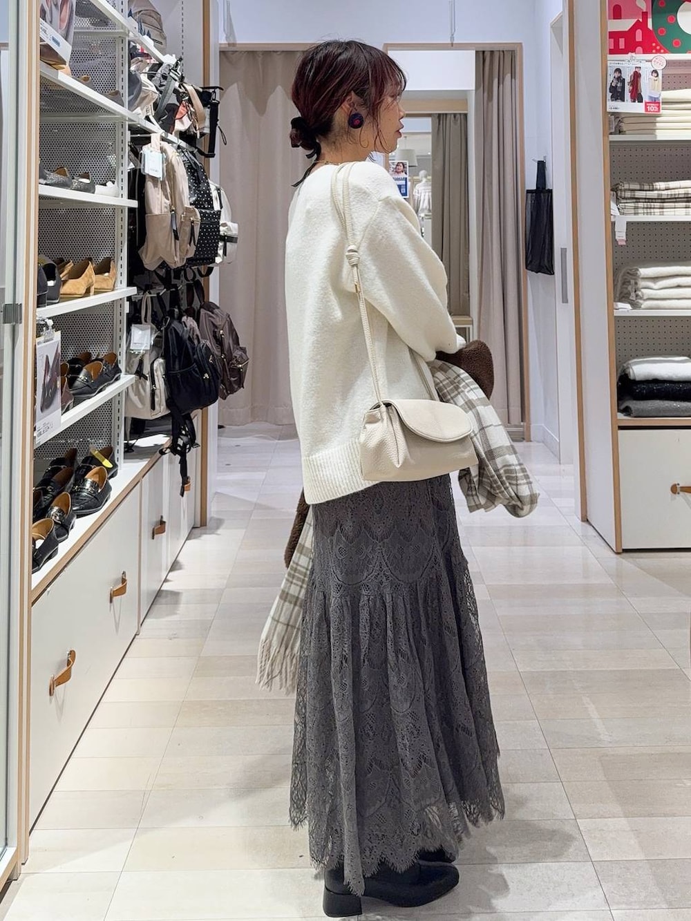 ベージュ系のショルダーバッグ、ブラック系のブーツ、ブラウン系のテーラードジャケットを着用したレディースの冬コーディネートの8枚目の写真