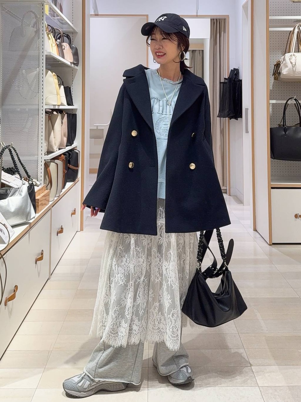 ブルー系のチェスターコート、グレー系のワンピース、ブルー系のスウェットを着用したレディースの冬コーディネートの2枚目の写真