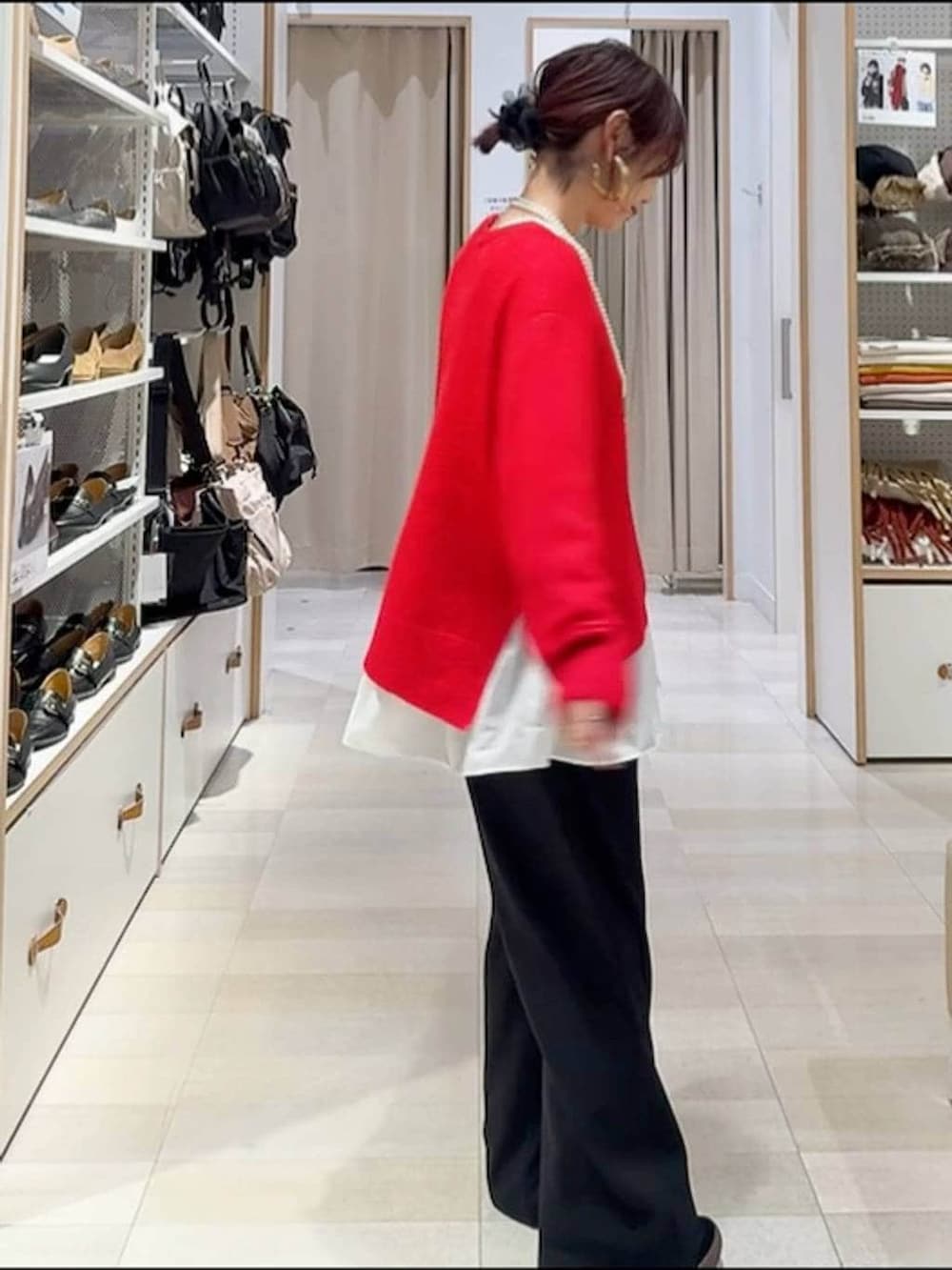 ブラック系のスニーカー、ブラウン系のボストンバッグ、ホワイト系のブルゾンを着用したレディースの冬コーディネートの6枚目の写真