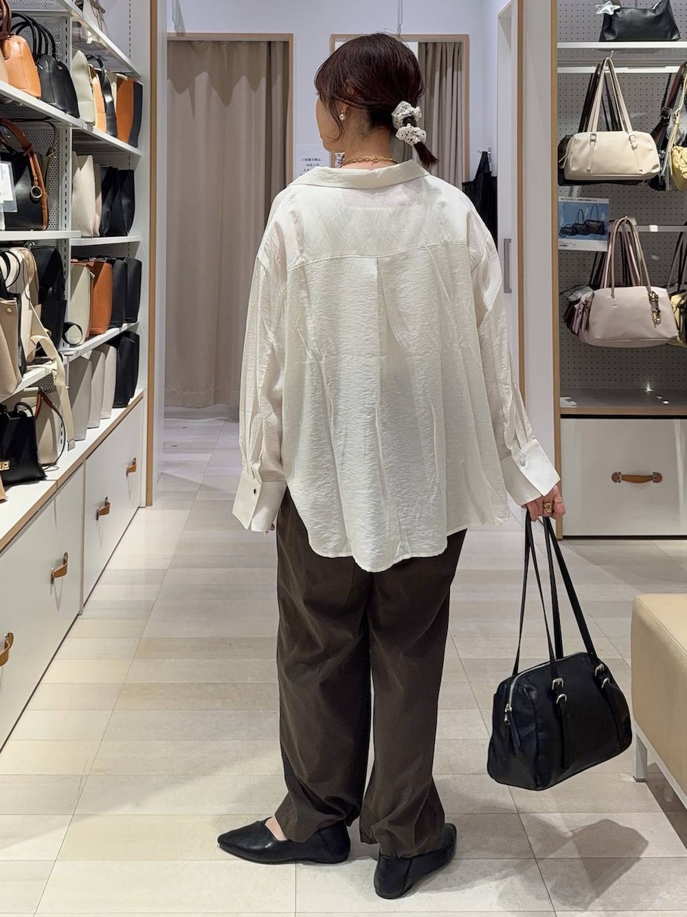 ブラック系のパンプス、ブラウン系のその他パンツ、ホワイト系のタンクトップを着用したレディースの春コーディネートの4枚目の写真