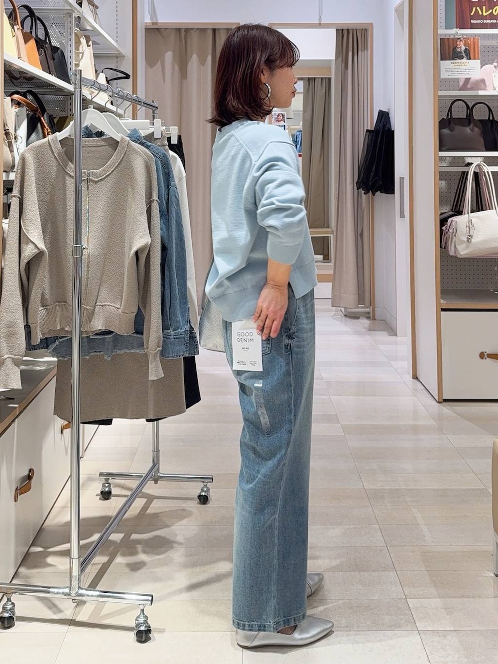 シルバー系のパンプス、ブラック系のキャミソール、ブルー系のデニムパンツを着用したレディースの冬コーディネートの8枚目の写真