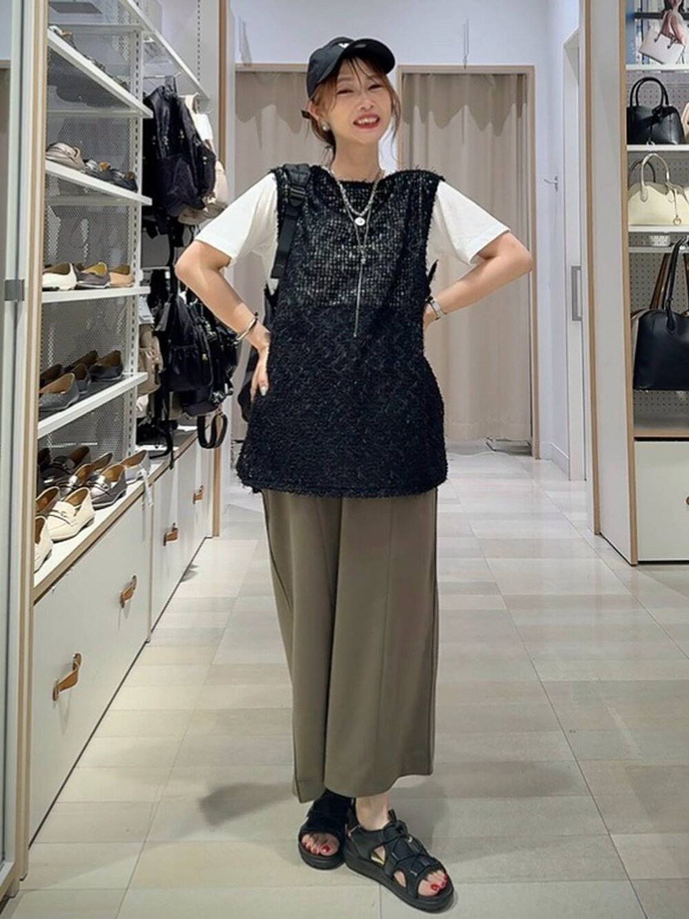 ブラック系のショルダーバッグ、ホワイト系のTシャツ/カットソー、グリーン系のスカートを着用したレディースの夏コーディネートの2枚目の写真