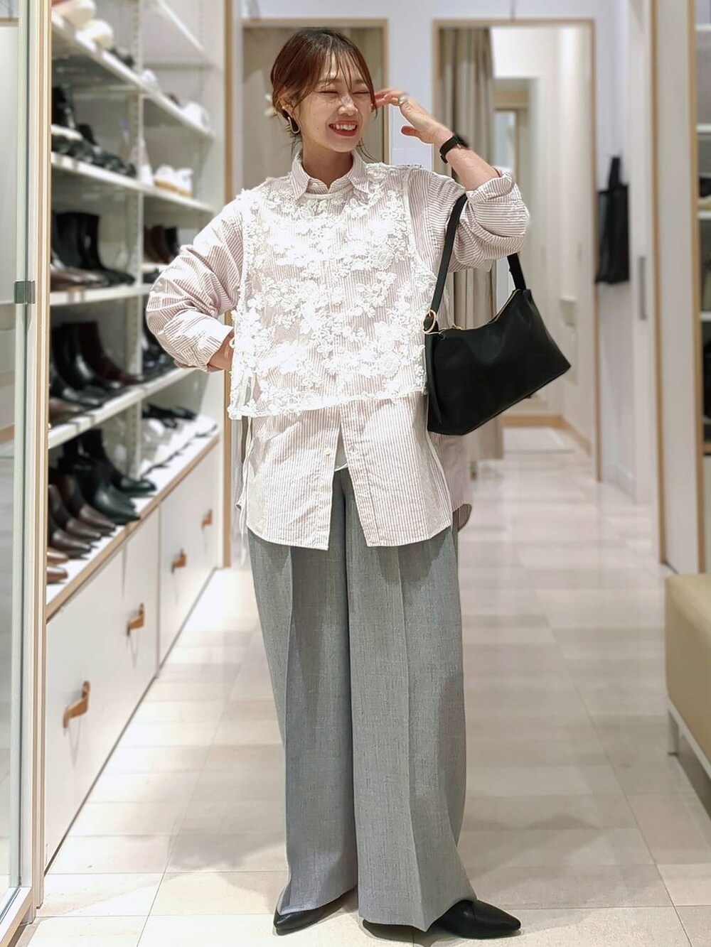 ブラック系のスニーカー、ホワイト系のショルダーバッグ、ピンク系のシャツ/ブラウスを着用したレディースの春コーディネートの2枚目の写真