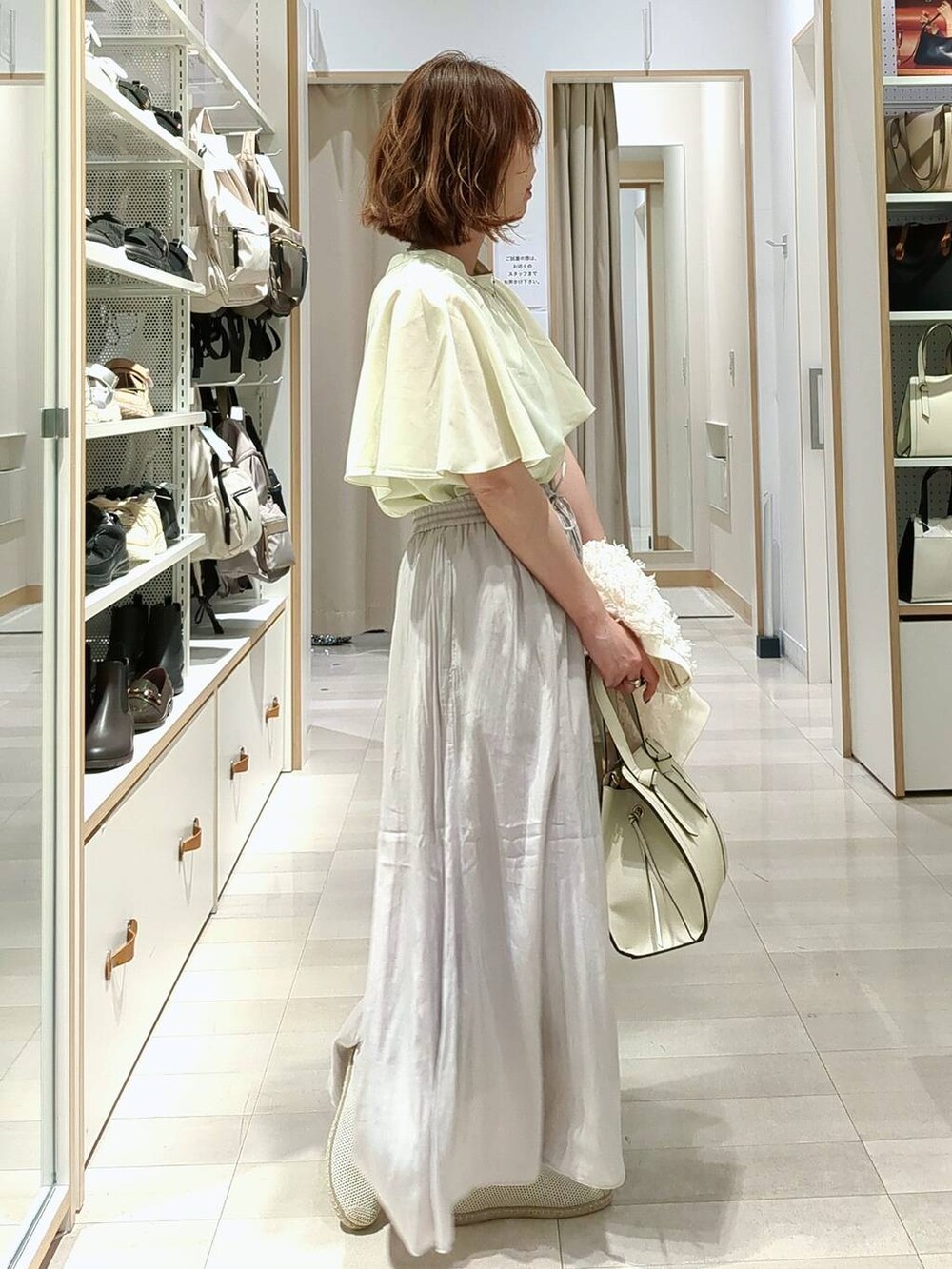 ベージュ系のその他パンツ、ホワイト系のショルダーバッグ、ホワイト系のスリッポンを着用したレディースの春コーディネートの6枚目の写真