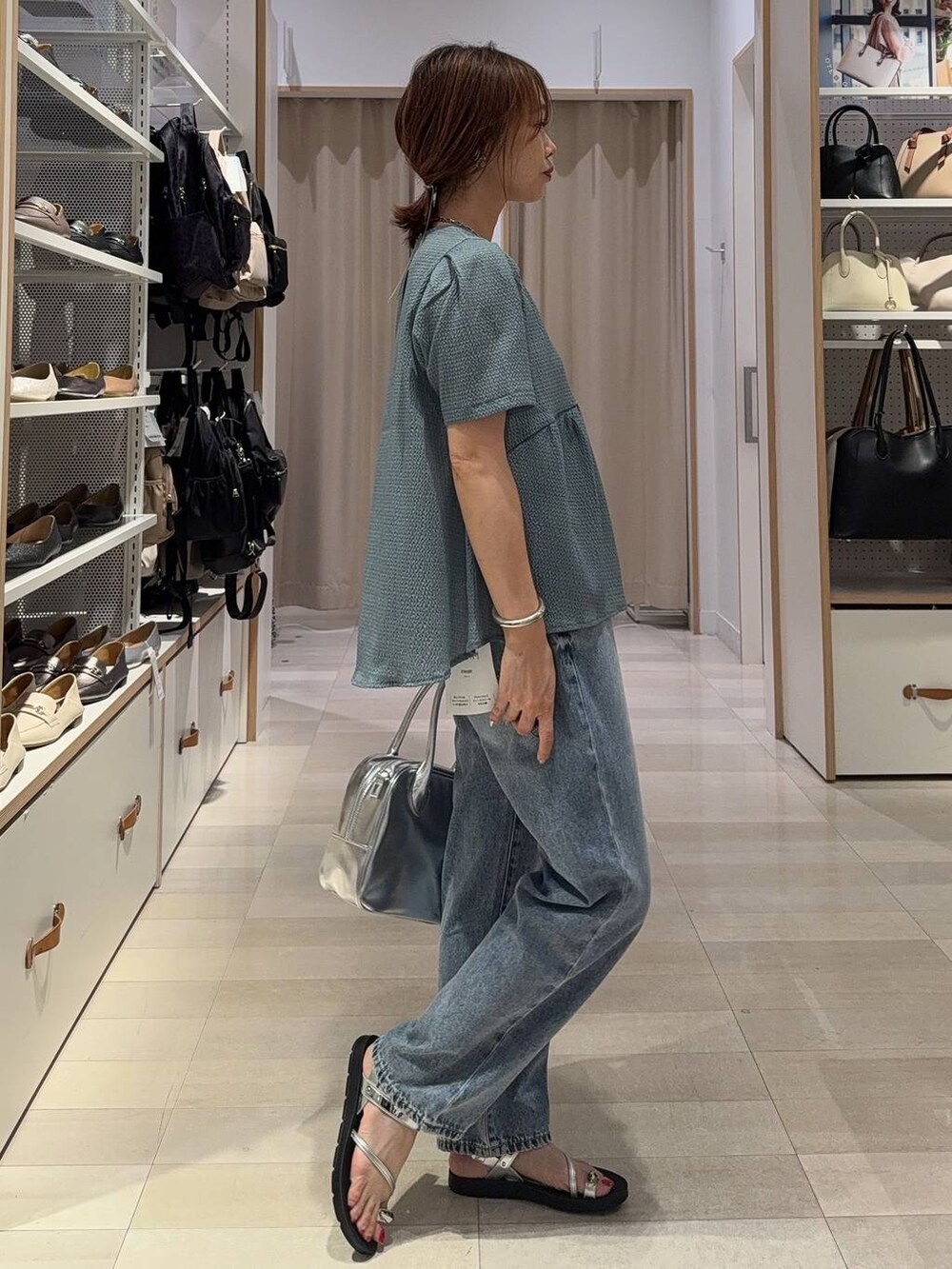 ブルー系のデニムパンツ、グレー系のボストンバッグ、ブラック系のカーディガン/ボレロを着用したレディースの夏コーディネートの8枚目の写真
