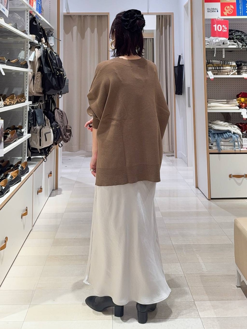 ブラック系のその他アウター、ブラック系のブーツ、グレー系のスカートを着用したレディースの冬コーディネートの8枚目の写真