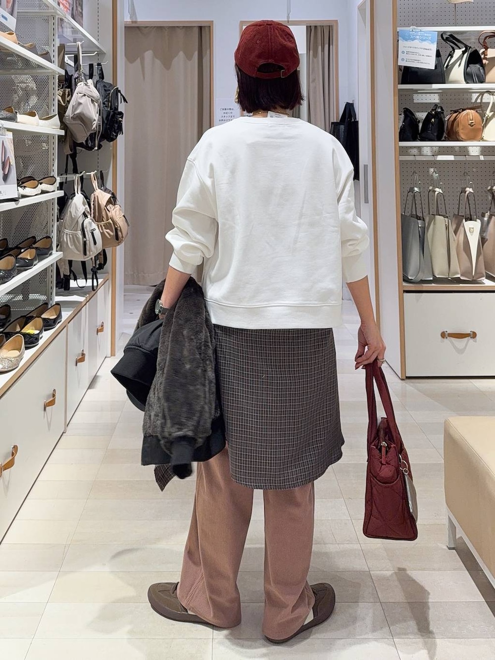 レッド系のトートバッグ、ブラック系のブルゾン、ピンク系のその他パンツを着用したレディースの秋コーディネートの7枚目の写真