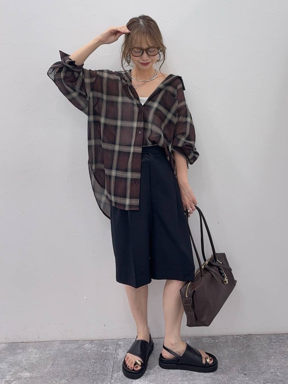 ブラック系のその他パンツ、ブラウン系のシャツ/ブラウス、シルバー系のネックレスを着用したレディースの夏コーディネートの6枚目の写真
