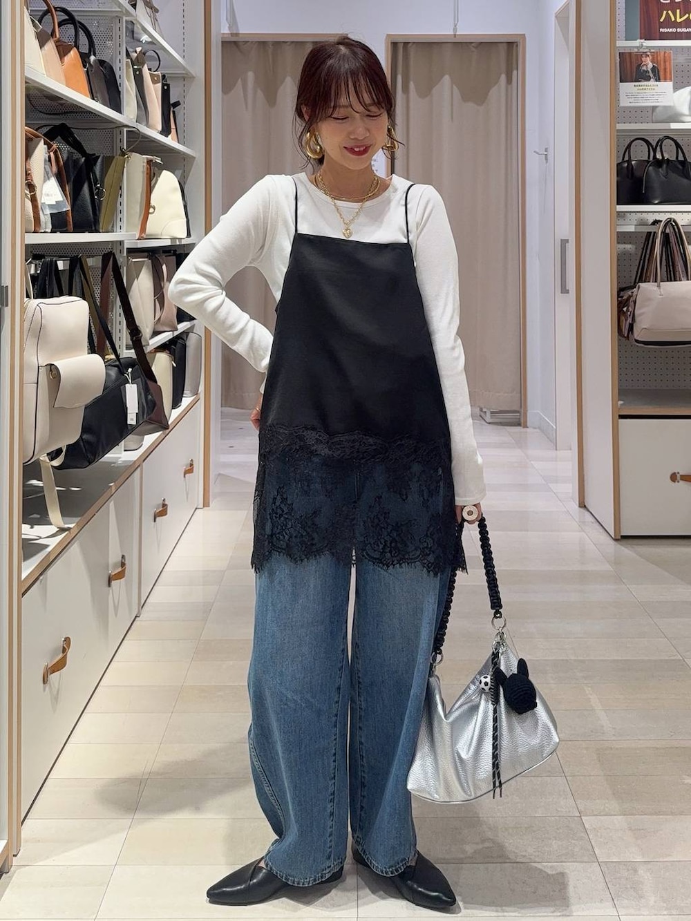 ブラック系のパンプス、グレー系のパーカー、ブルー系のデニムパンツを着用したレディースの冬コーディネートの2枚目の写真