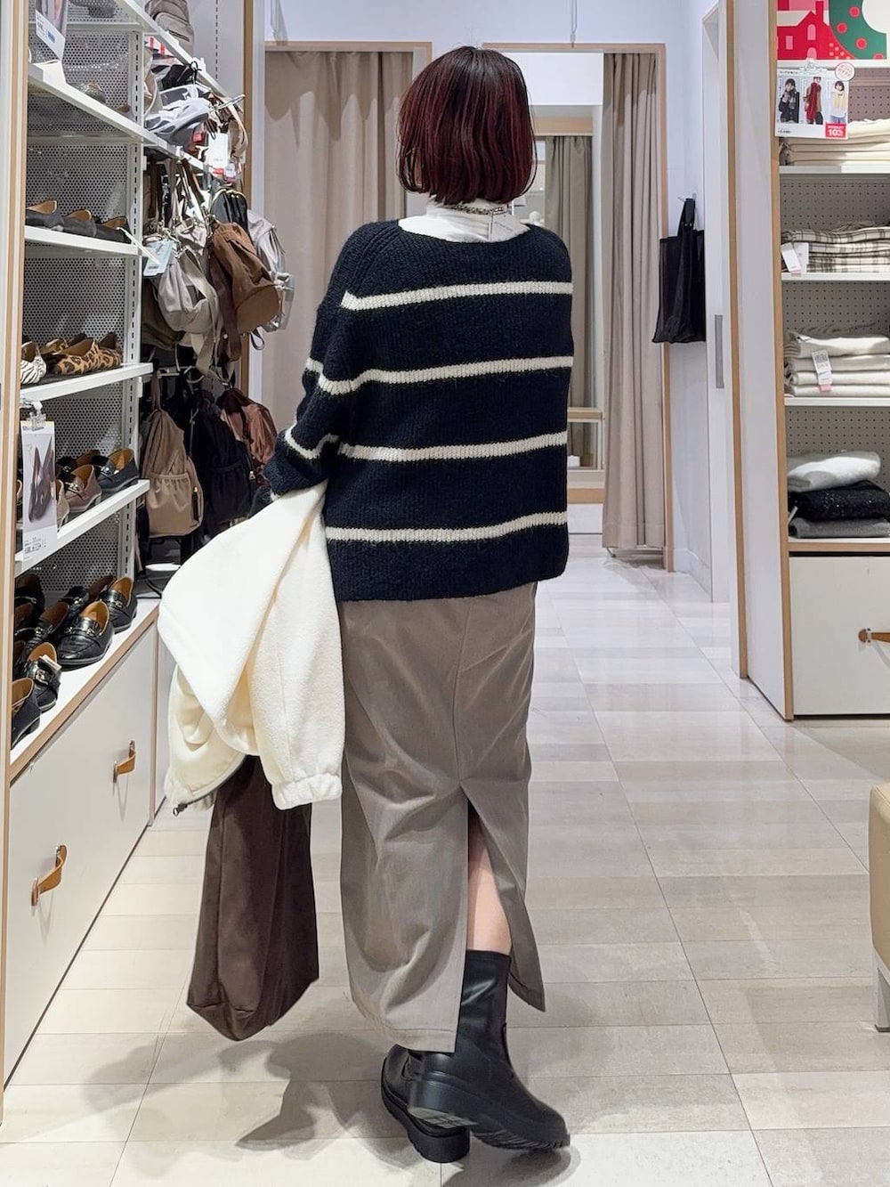 ブラウン系のスカート、ブラウン系のトートバッグ、ホワイト系のTシャツ/カットソーを着用したレディースの冬コーディネートの7枚目の写真