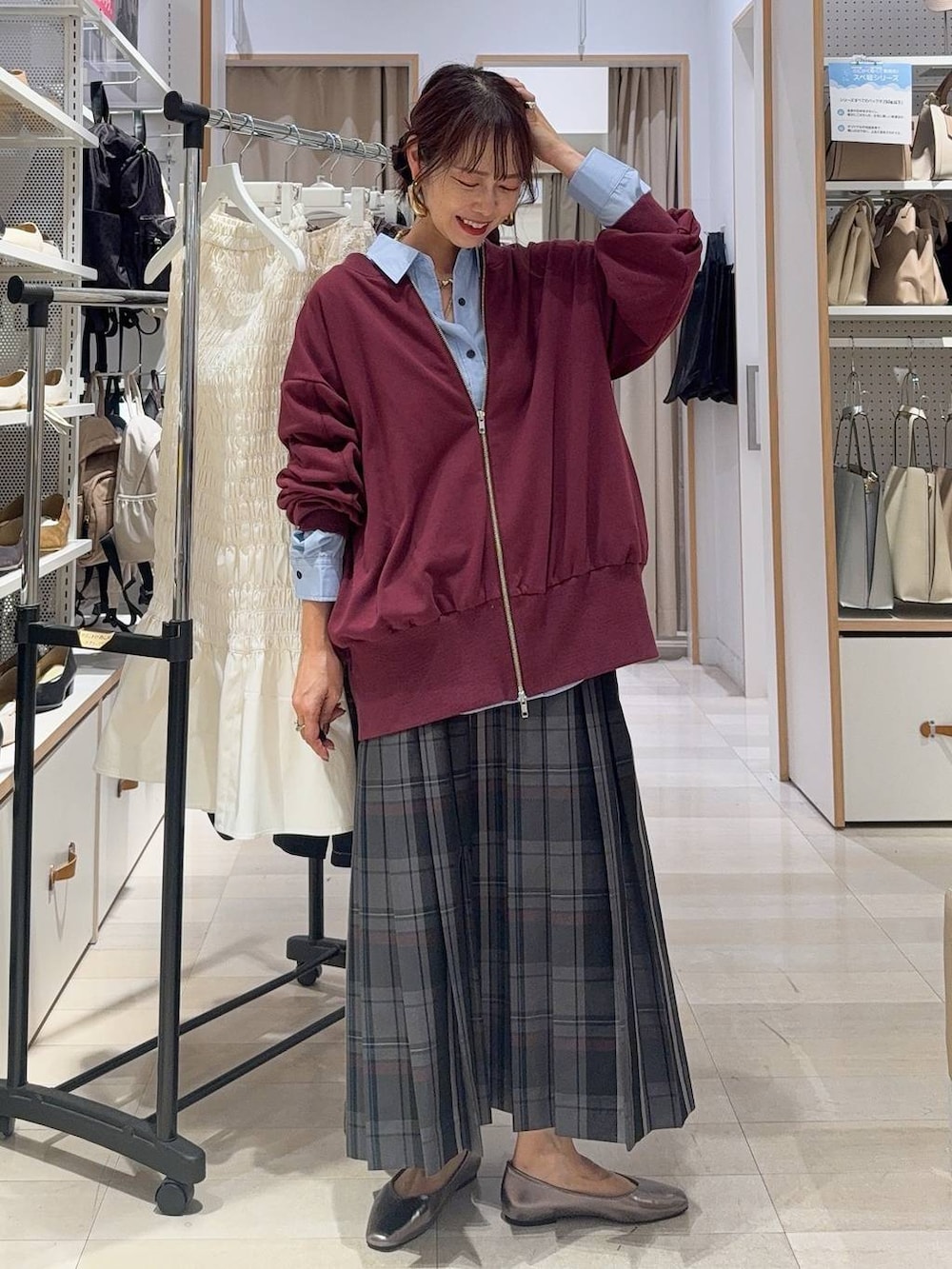 ホワイト系のキャミソール、ブルー系のデニムパンツ、ブラック系のボストンバッグを着用したレディースの秋コーディネートの7枚目の写真