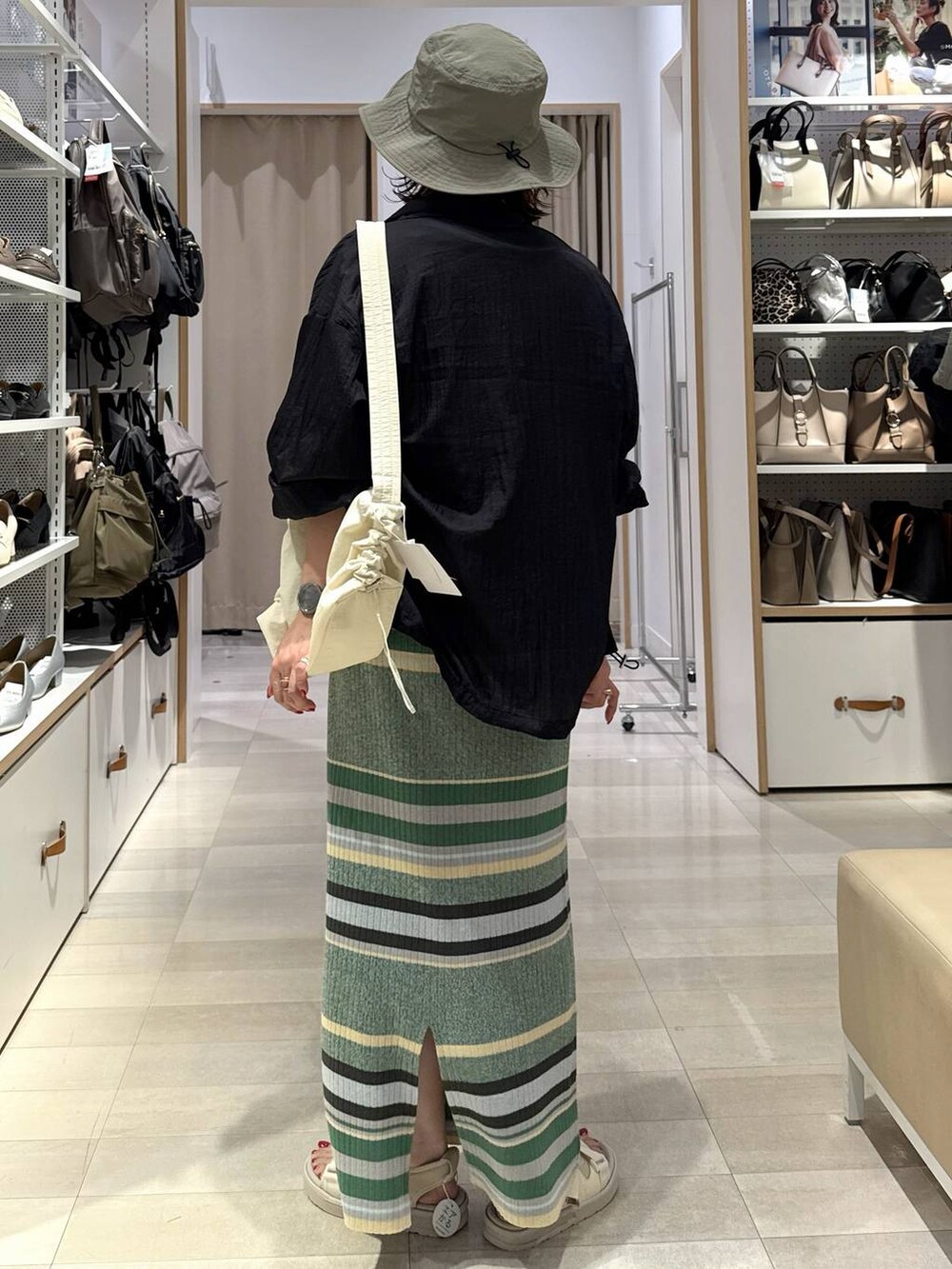 ブラック系のTシャツ/カットソー、ブラック系のブルゾン、グリーン系のスカートを着用したレディースの春コーディネートの6枚目の写真