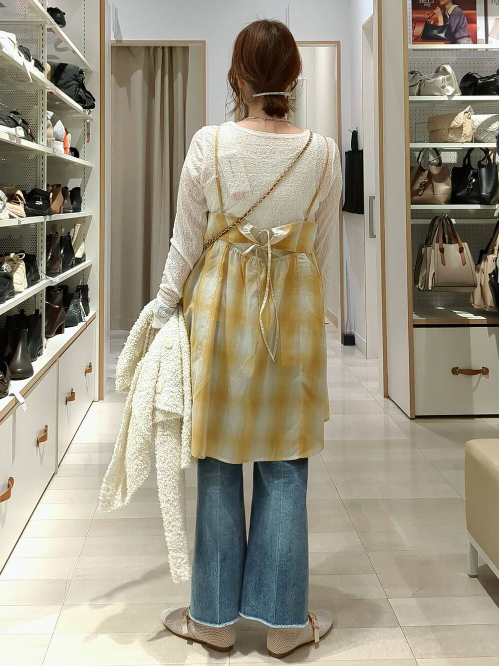 ブルー系のデニムパンツ、ベージュ系のショルダーバッグ、ホワイト系のTシャツ/カットソーを着用したレディースの春コーディネートの7枚目の写真