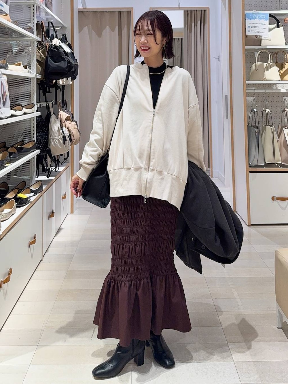 シルバー系のショルダーバッグ、ブラック系のバレエシューズ、ホワイト系のキャミソールを着用したレディースの冬コーディネートの2枚目の写真