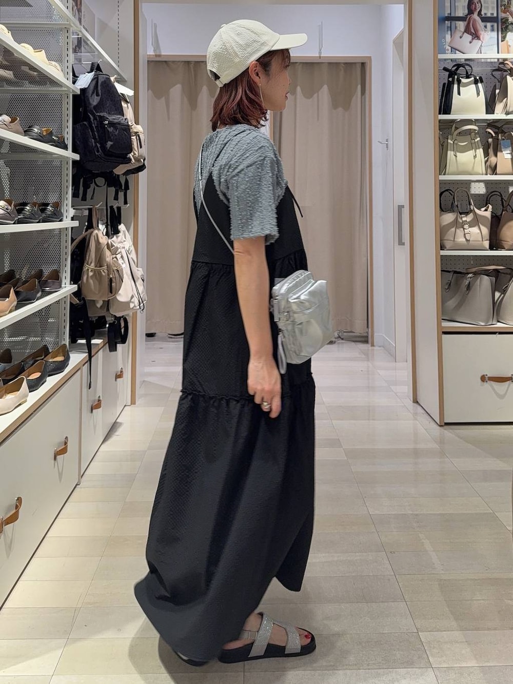 シルバー系のショルダーバッグ、グレー系のサンダル、ブラック系のワンピースを着用したレディースの夏コーディネートの3枚目の写真