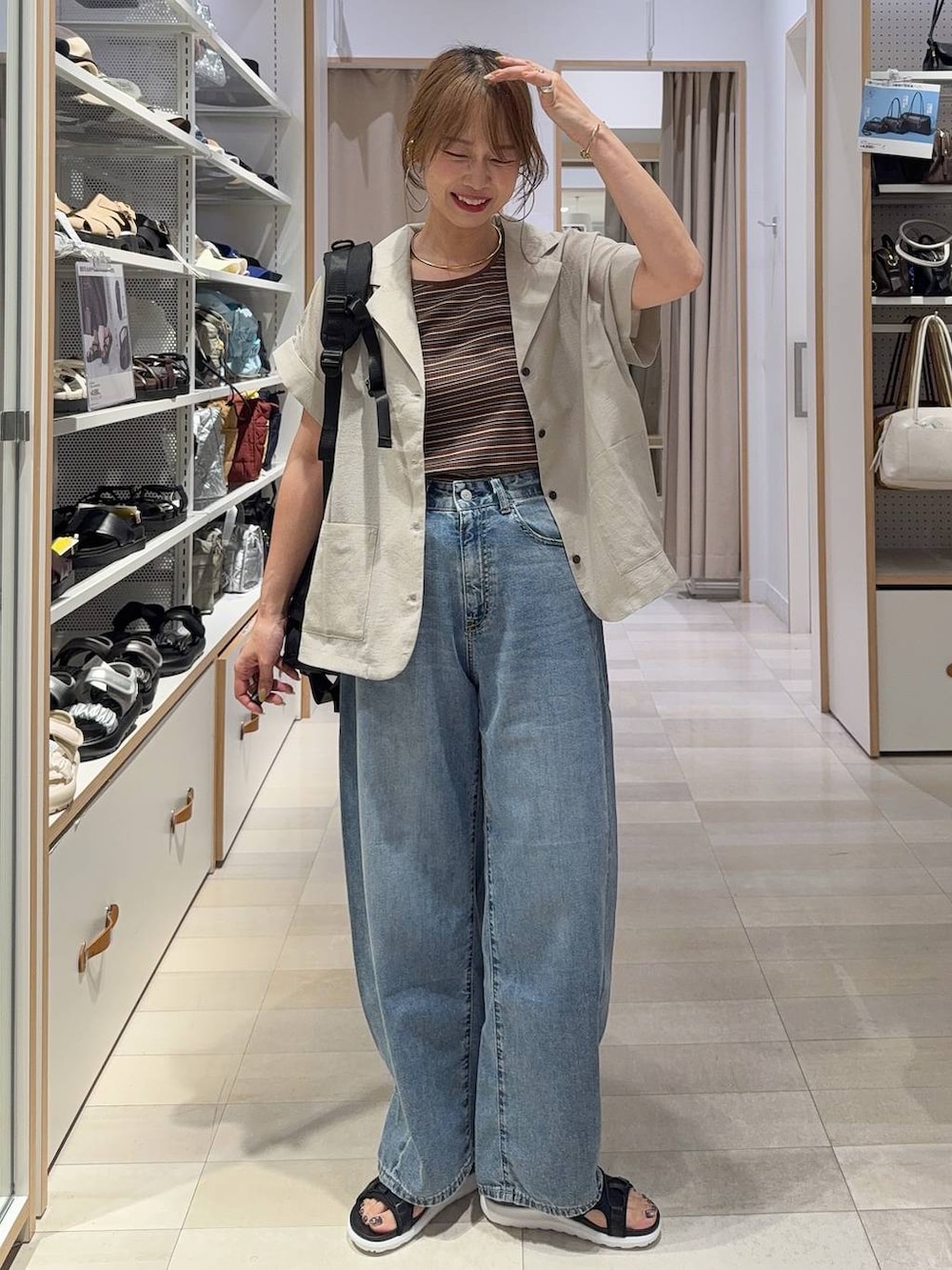 ブルー系のデニムパンツ、ホワイト系のタンクトップ、ブラウン系のシャツ/ブラウスを着用したレディースの春コーディネートの4枚目の写真