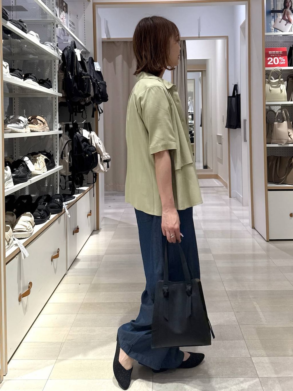 ブラック系のショルダーバッグ、イエロー系のシャツ/ブラウス、その他のタンクトップを着用したレディースの春コーディネートの2枚目の写真