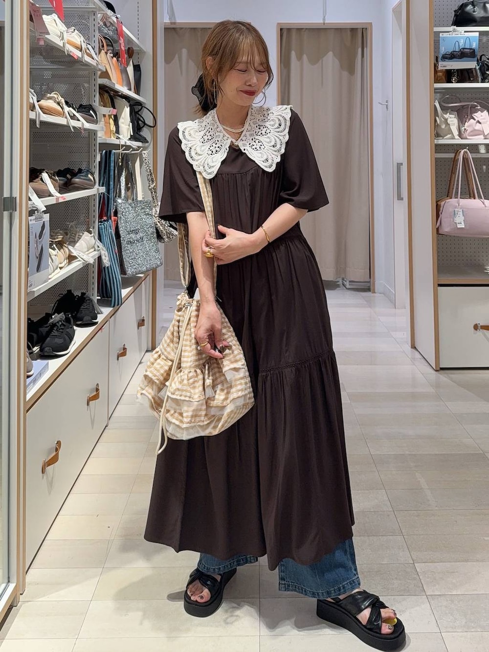 ブルー系のデニムパンツ、ブラウン系のワンピース、ブラック系のサンダルを着用したレディースの夏コーディネートの2枚目の写真