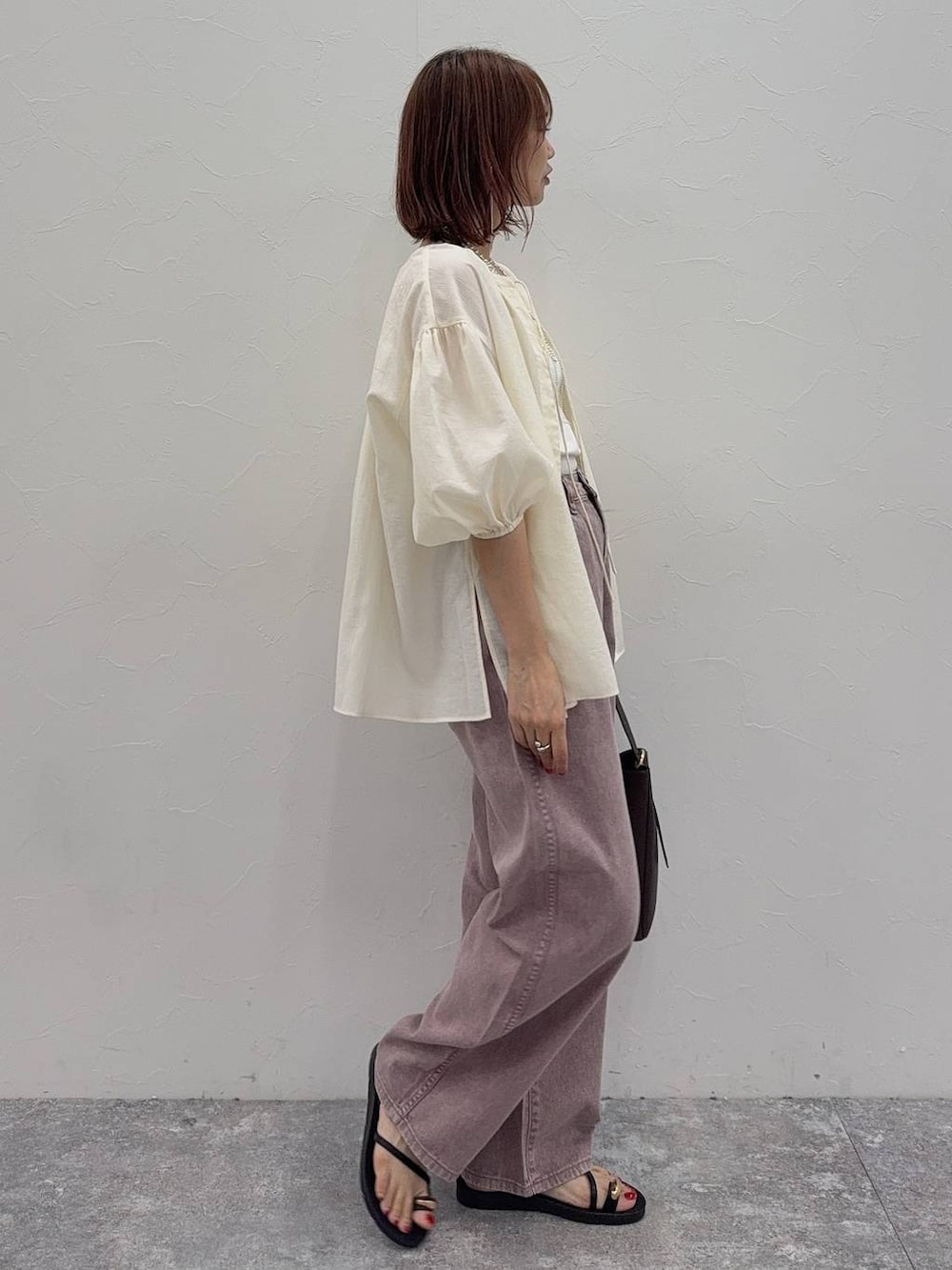 ブラウン系のショルダーバッグ、ホワイト系のキャミソール、ピンク系のデニムパンツを着用したレディースの夏コーディネートの3枚目の写真