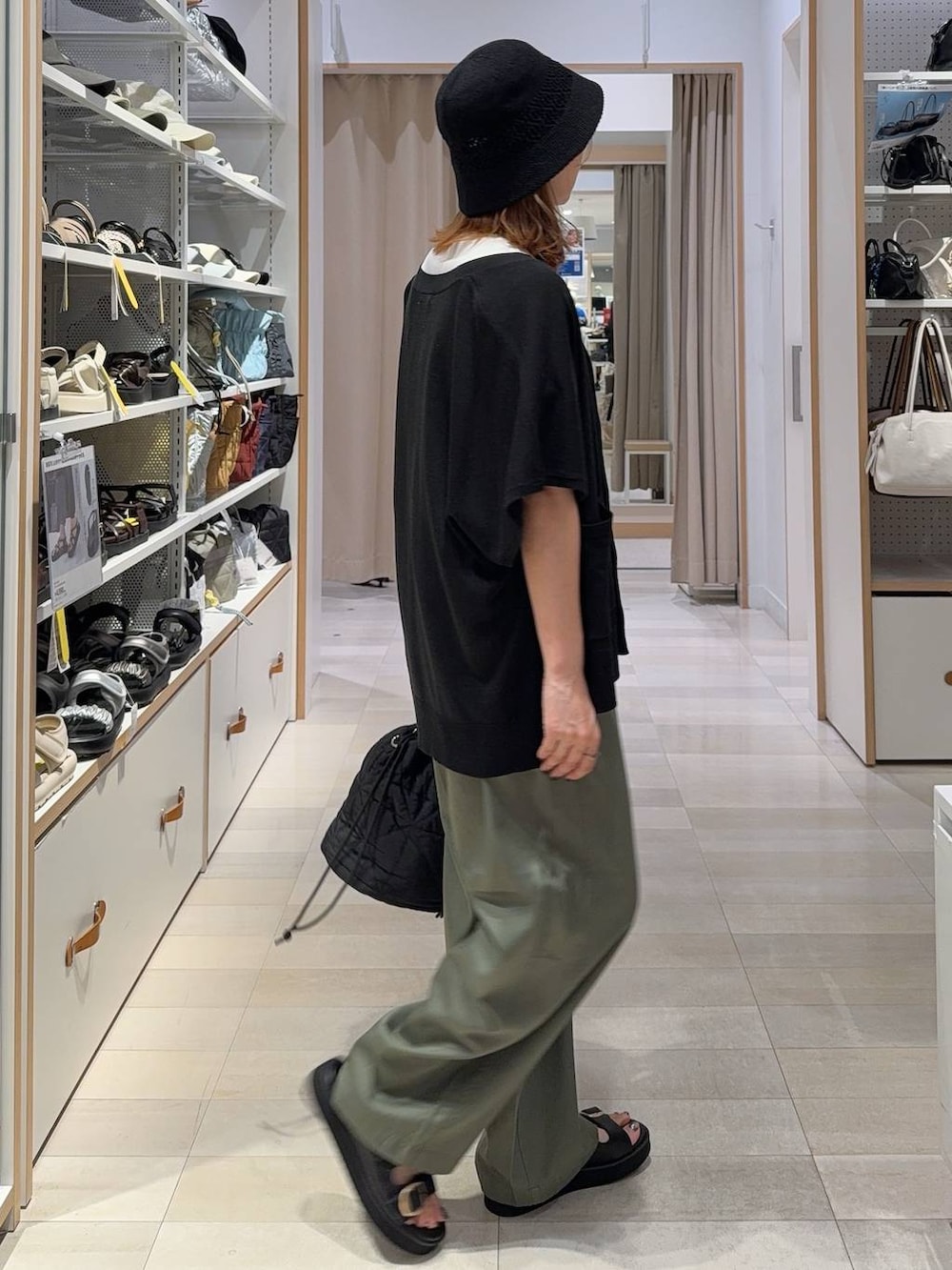 ブラック系のカーディガン/ボレロ、ブラック系のハンドバッグ、ホワイト系のTシャツ/カットソーを着用したレディースの夏コーディネートの4枚目の写真