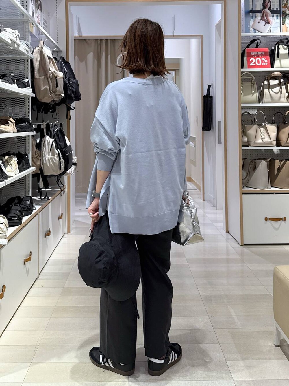 シルバー系のショルダーバッグ、ブルー系のカーディガン/ボレロ、ホワイト系のTシャツ/カットソーを着用したレディースの春コーディネートの5枚目の写真