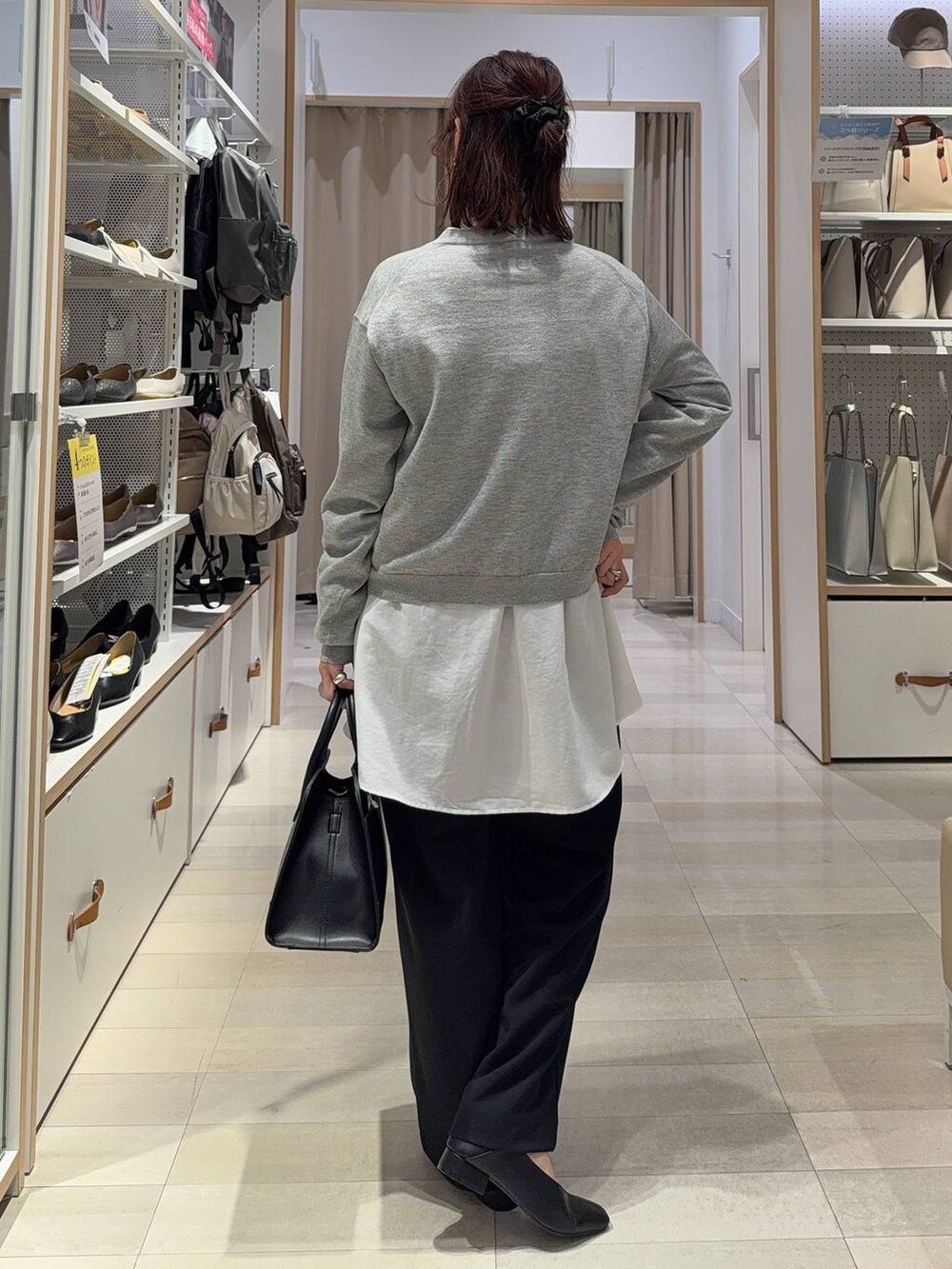 グレー系のカーディガン/ボレロ、ブラック系のショルダーバッグ、ホワイト系のシャツ/ブラウスを着用したレディースの秋コーディネートの4枚目の写真