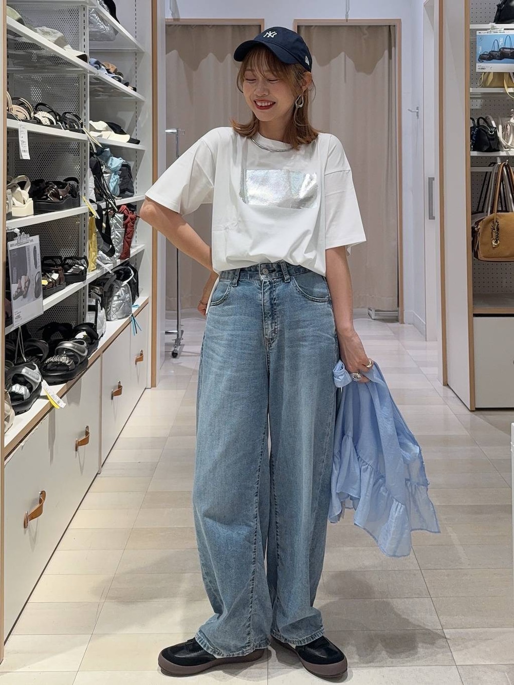 ブラック系のスニーカー、グレー系のバックパック/リュック、ホワイト系のTシャツ/カットソーを着用したレディースの夏コーディネートの2枚目の写真
